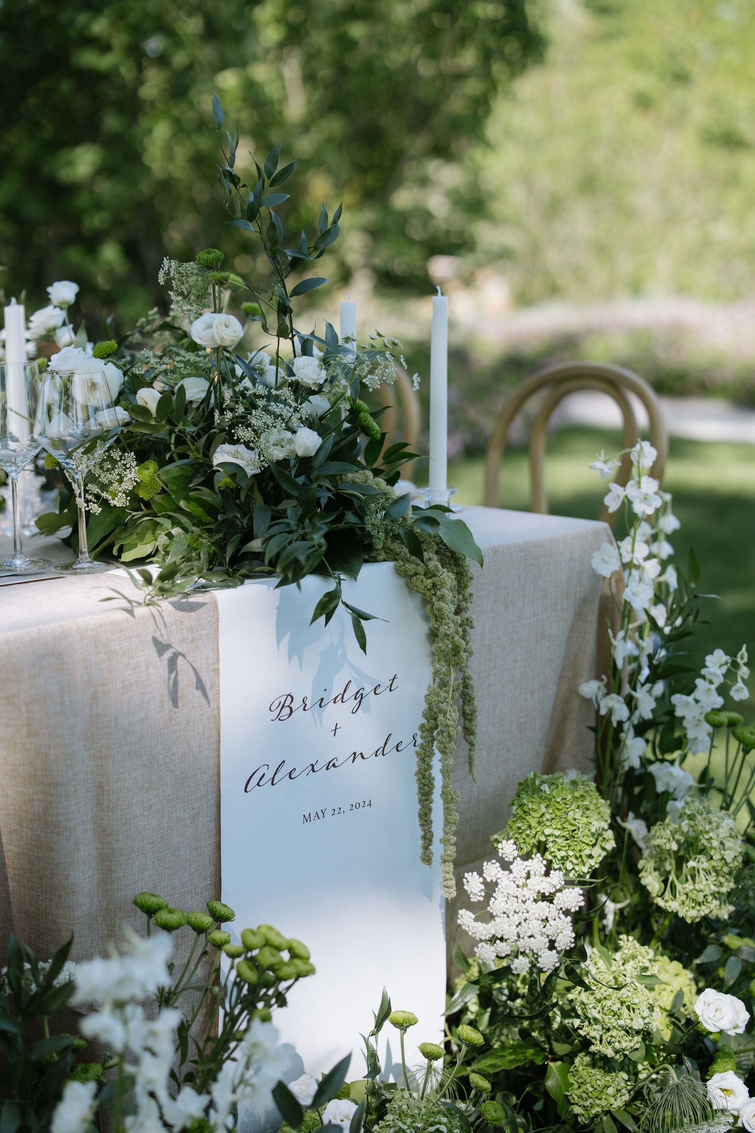 Wedding place cards decorated with white flowers and greenery.