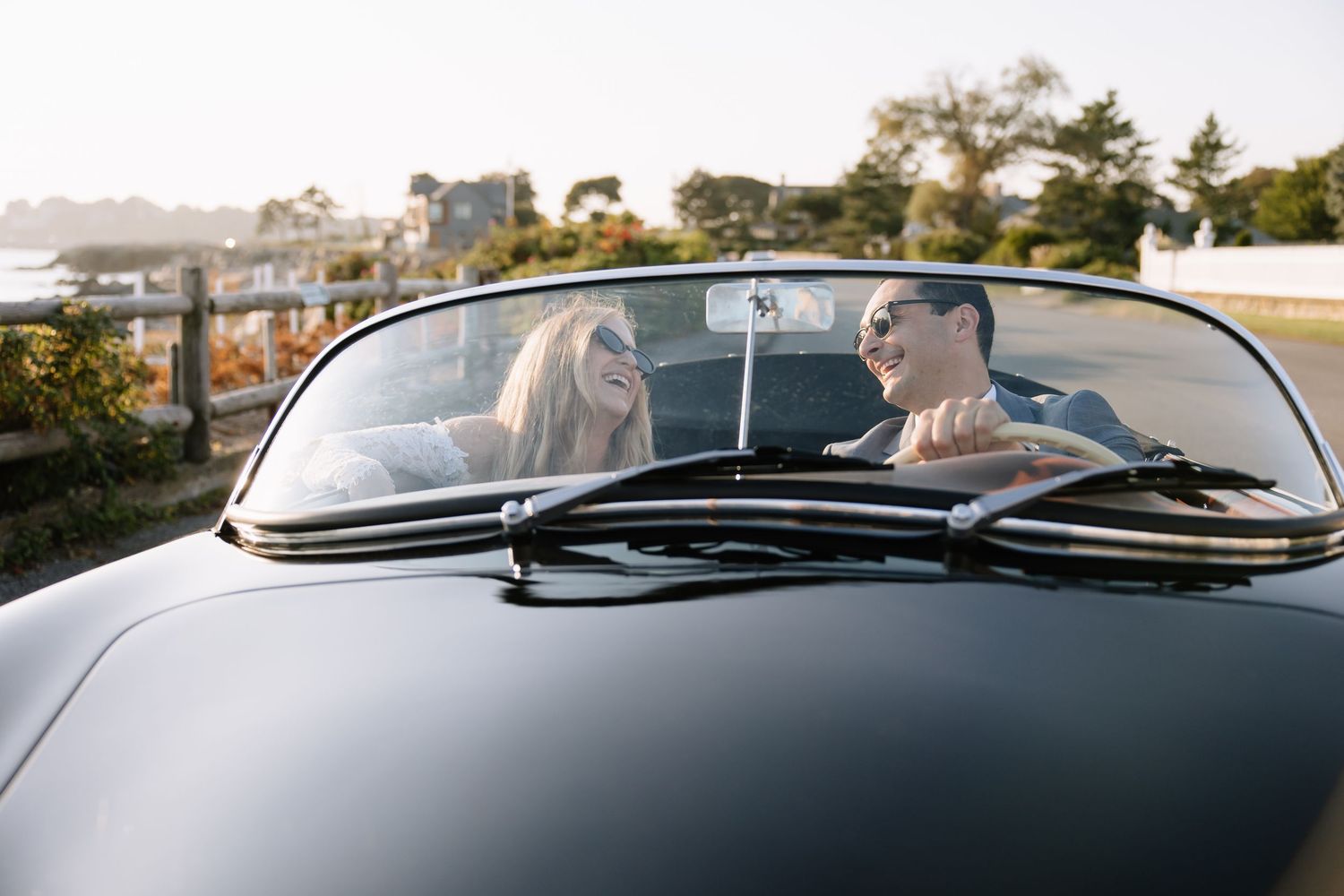 Wide angle shot through the windshield of a vintage convertible car with scenic backdrop.