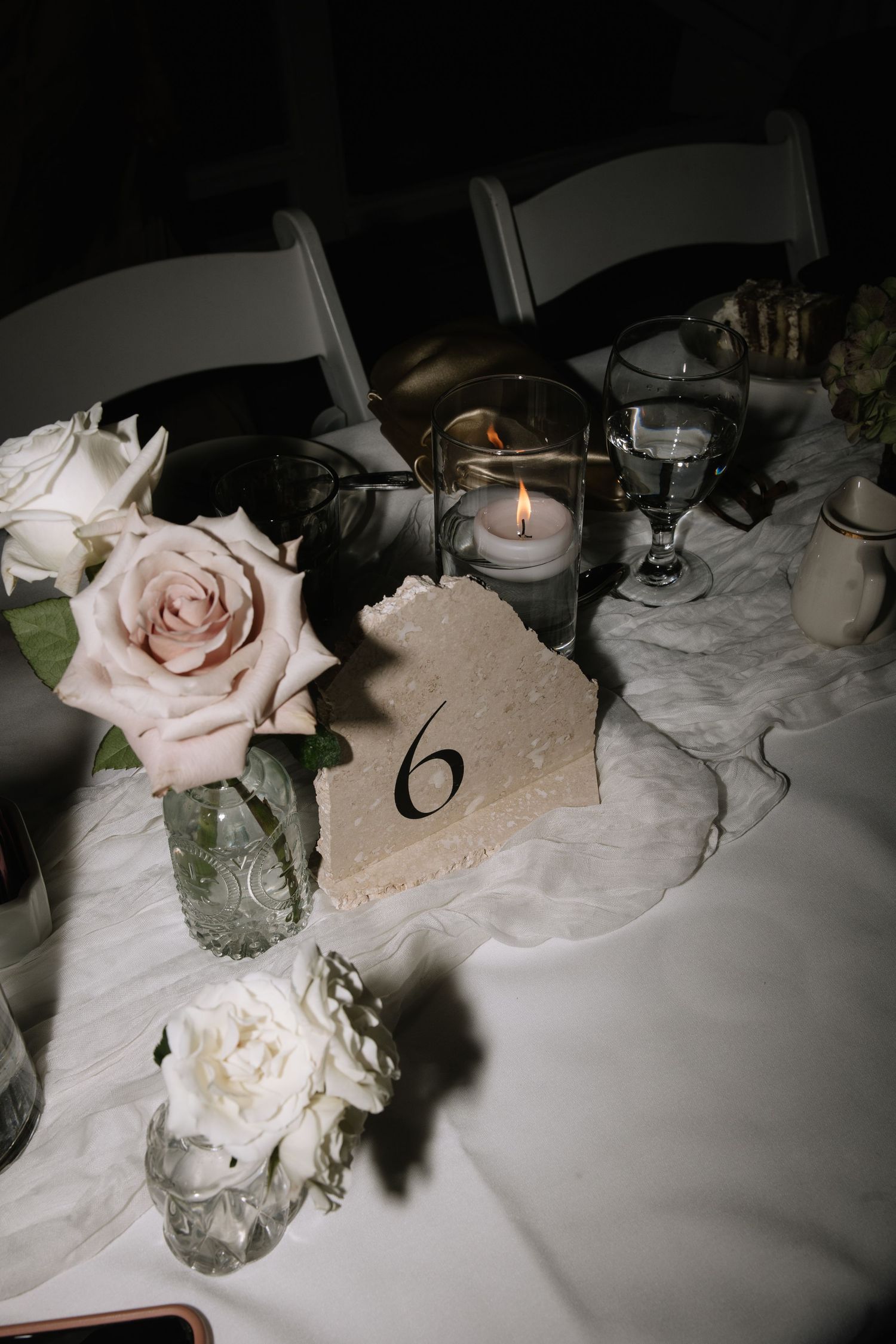 Romantic table setting with soft pink roses and candlelight creating an intimate atmosphere.