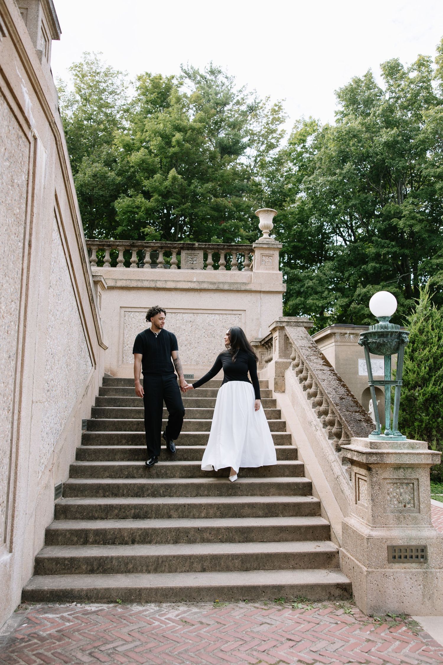 A series of stone steps with ornate railings lead up to a garden terrace at a historic estate.
