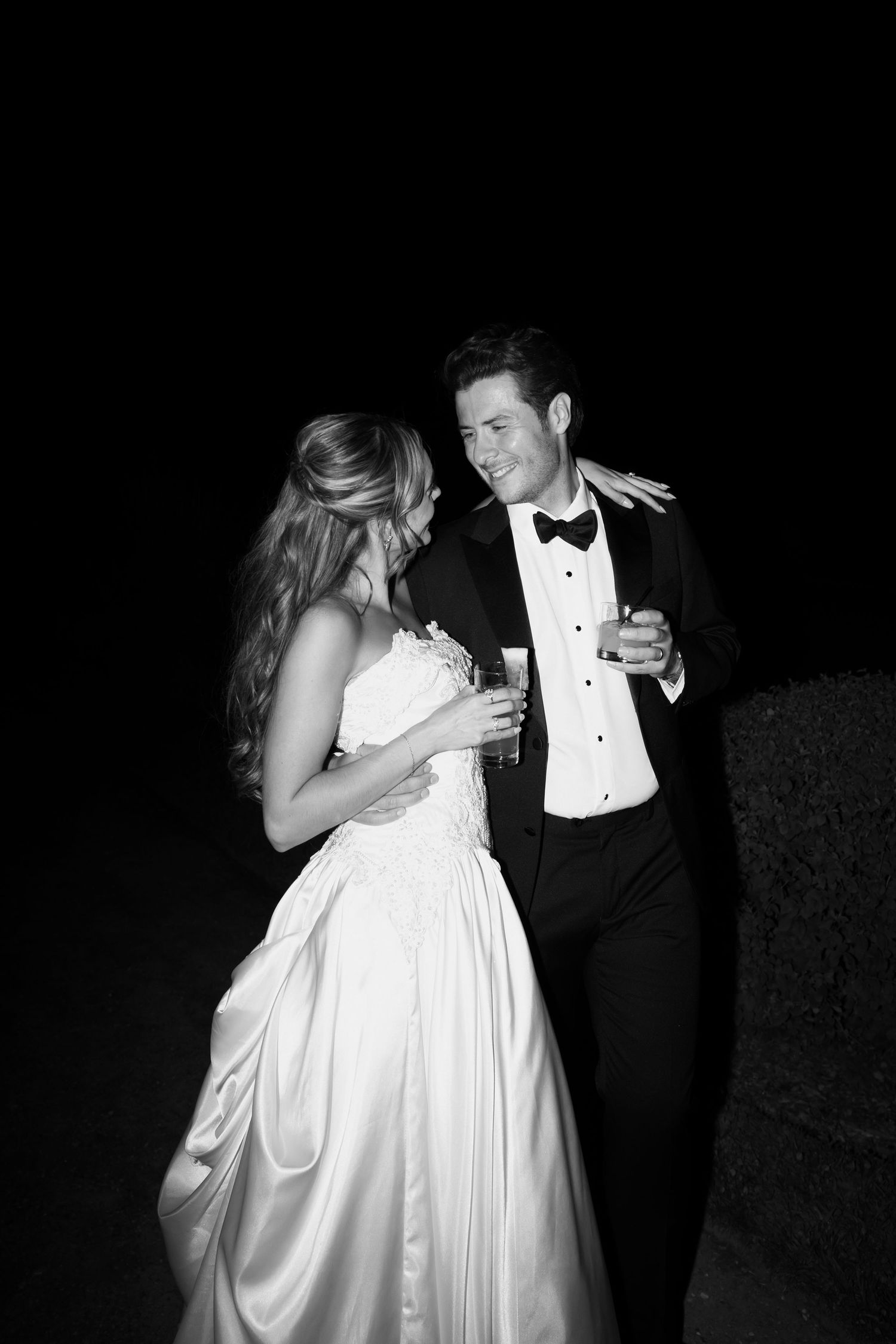 A couple shares an intimate dance moment at their wedding reception, with the bride in a white gown.
