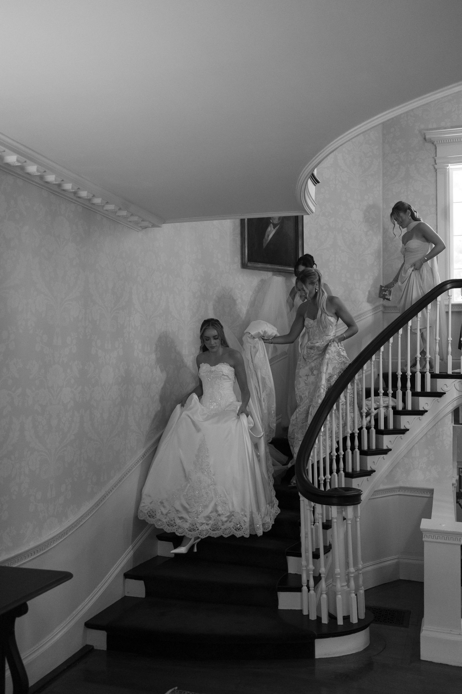 Artistic sequence showing bride in white gown descending elegant staircase in black and white.