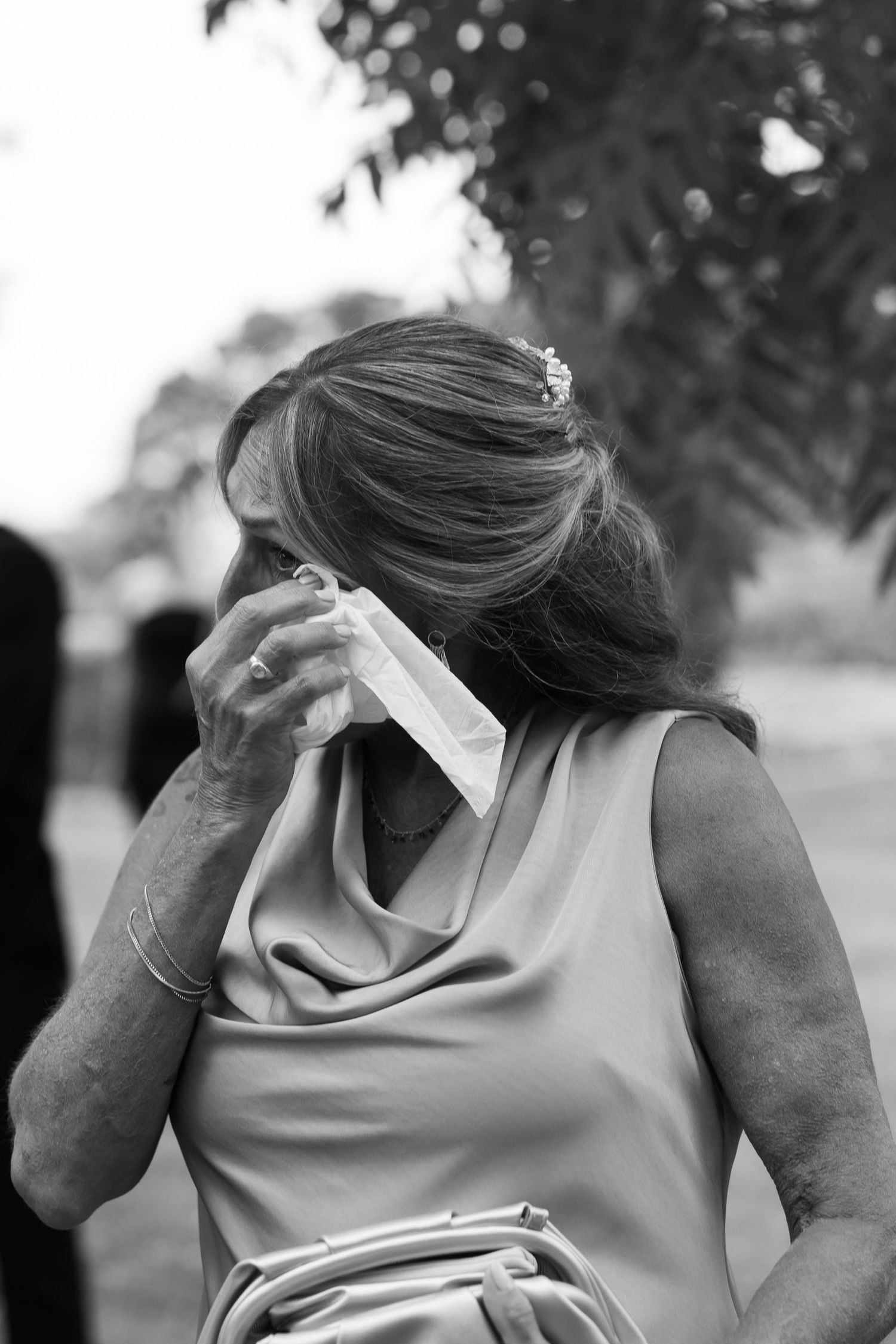 Emotional moment captured in black and white showing embraces and tears at a formal event.