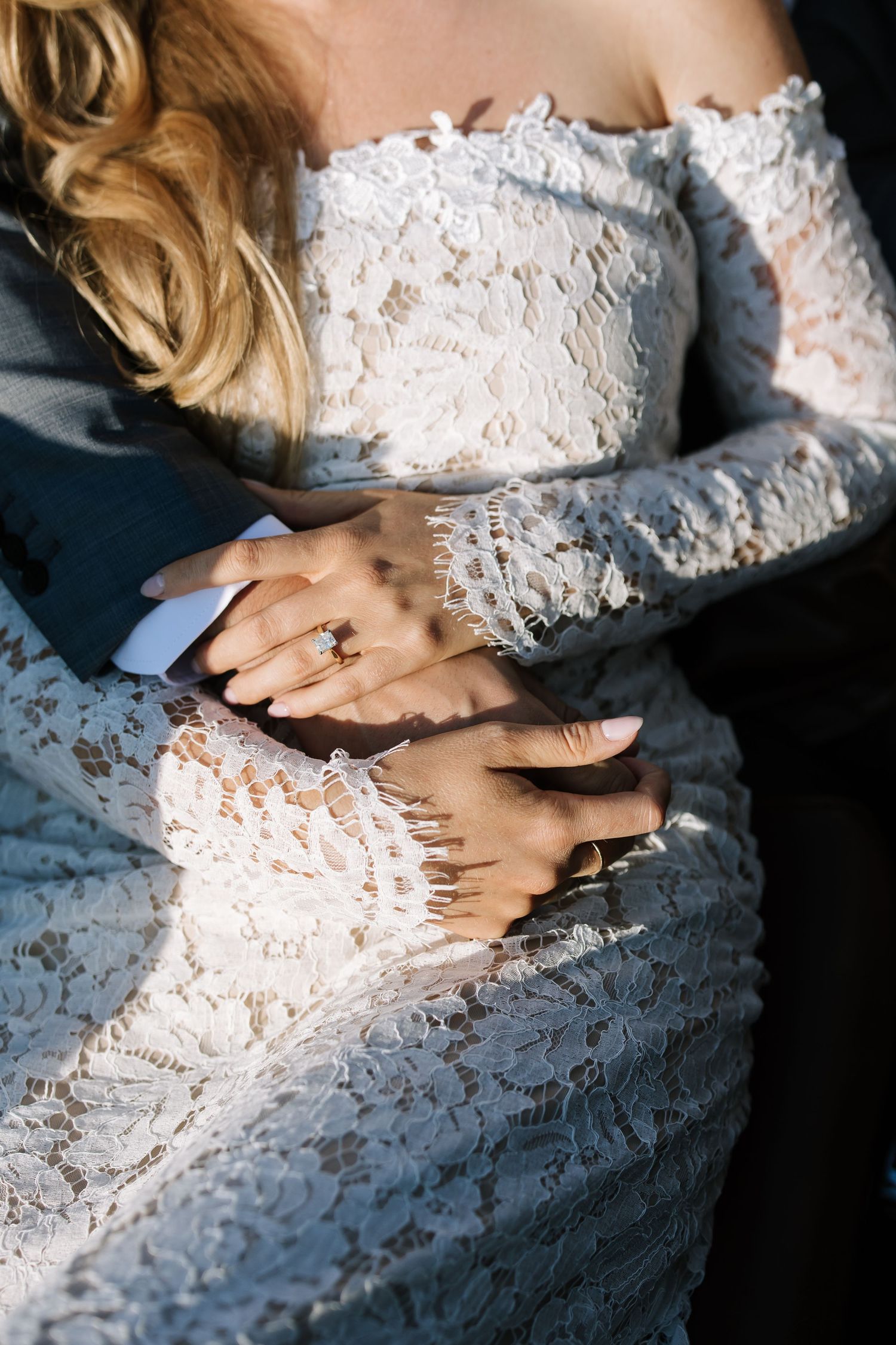 Close-up detail of lace wedding dress fabric with dramatic lighting.