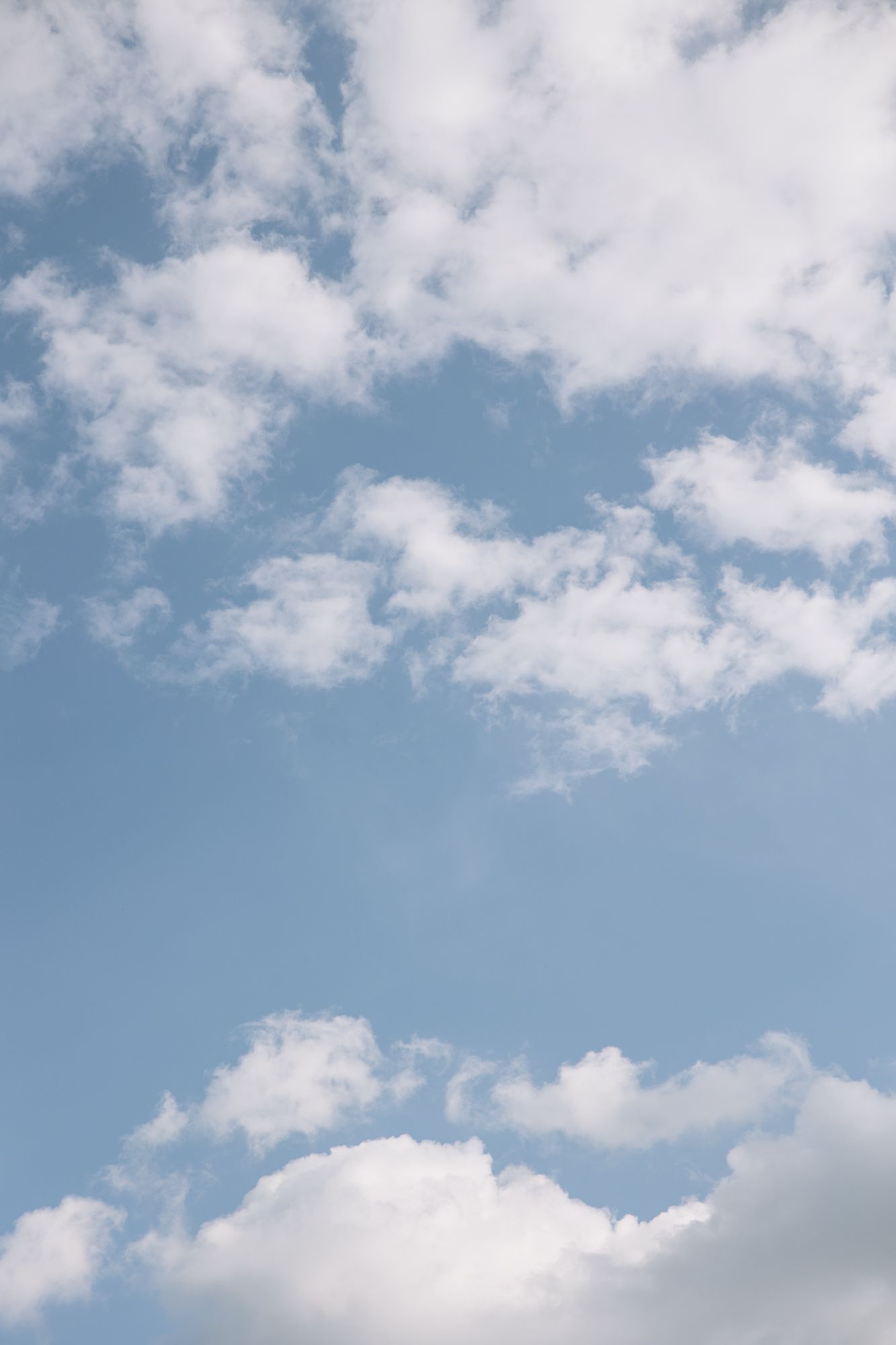 Dreamy blue sky with scattered white clouds creating a perfect wedding day backdrop.