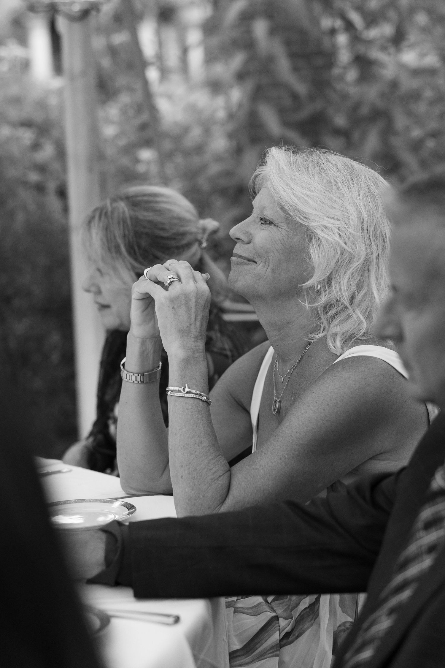 Black and white photo of wedding guests reacting emotionally during reception speeches.