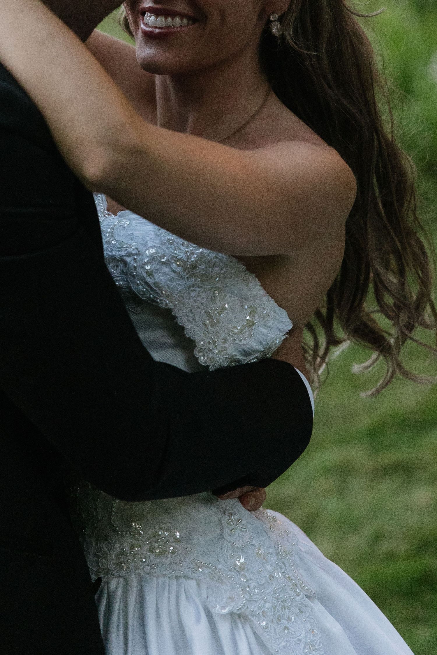 Close-up details of a sparkly white wedding dress bodice with intricate beading.