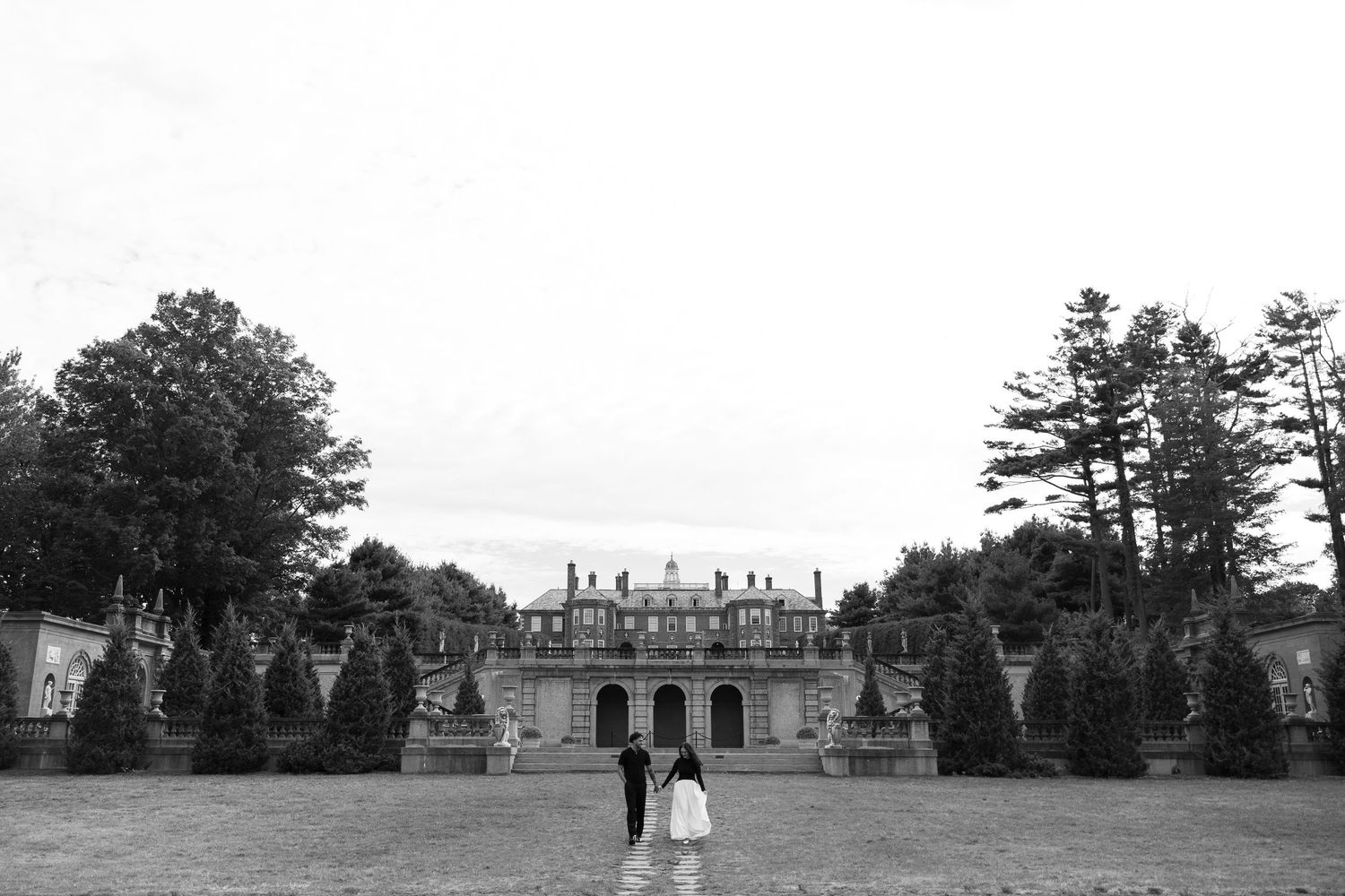 Black and white panoramic view of a grand estate with manicured grounds.