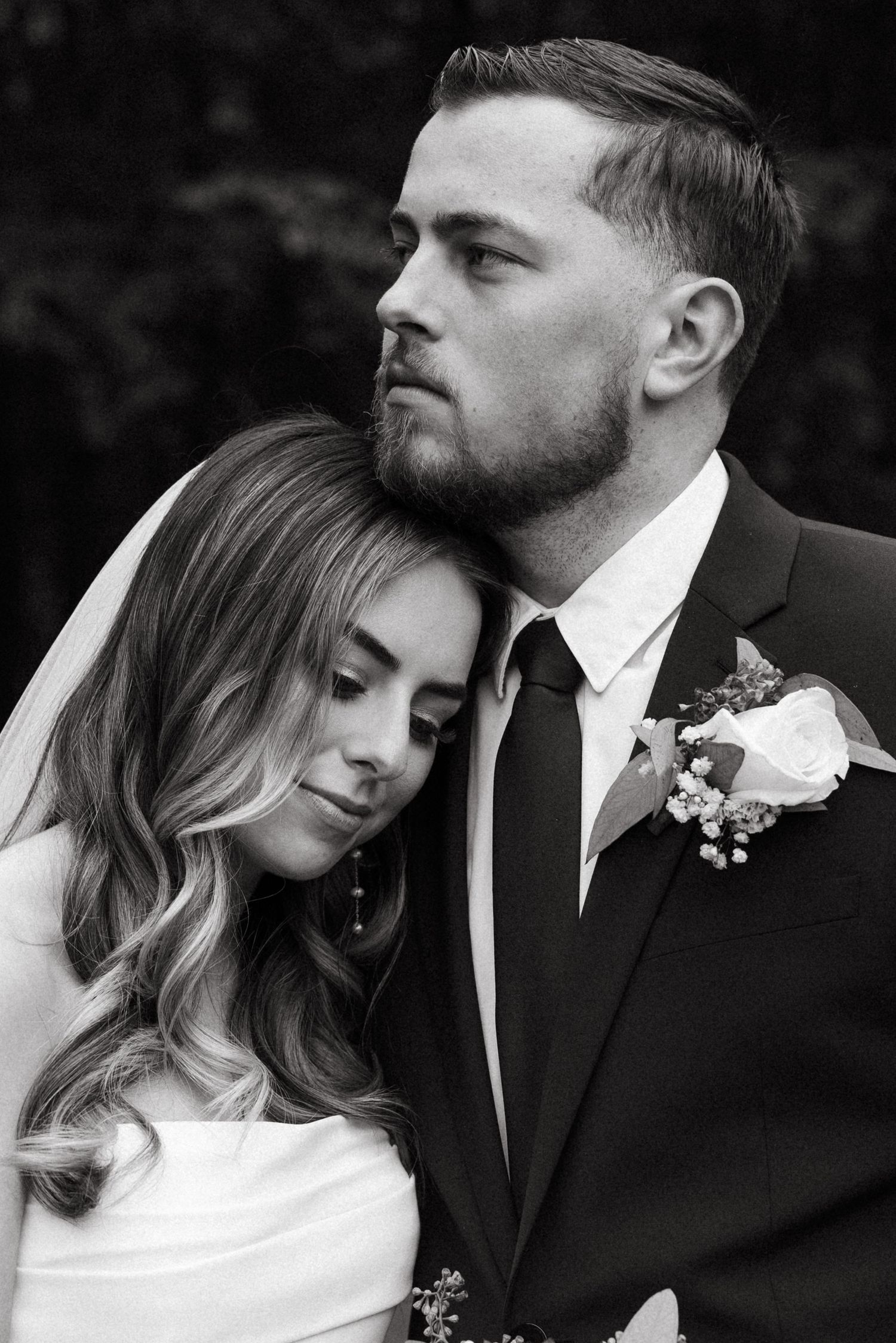 Intimate black and white portrait of newlyweds in romantic pose.