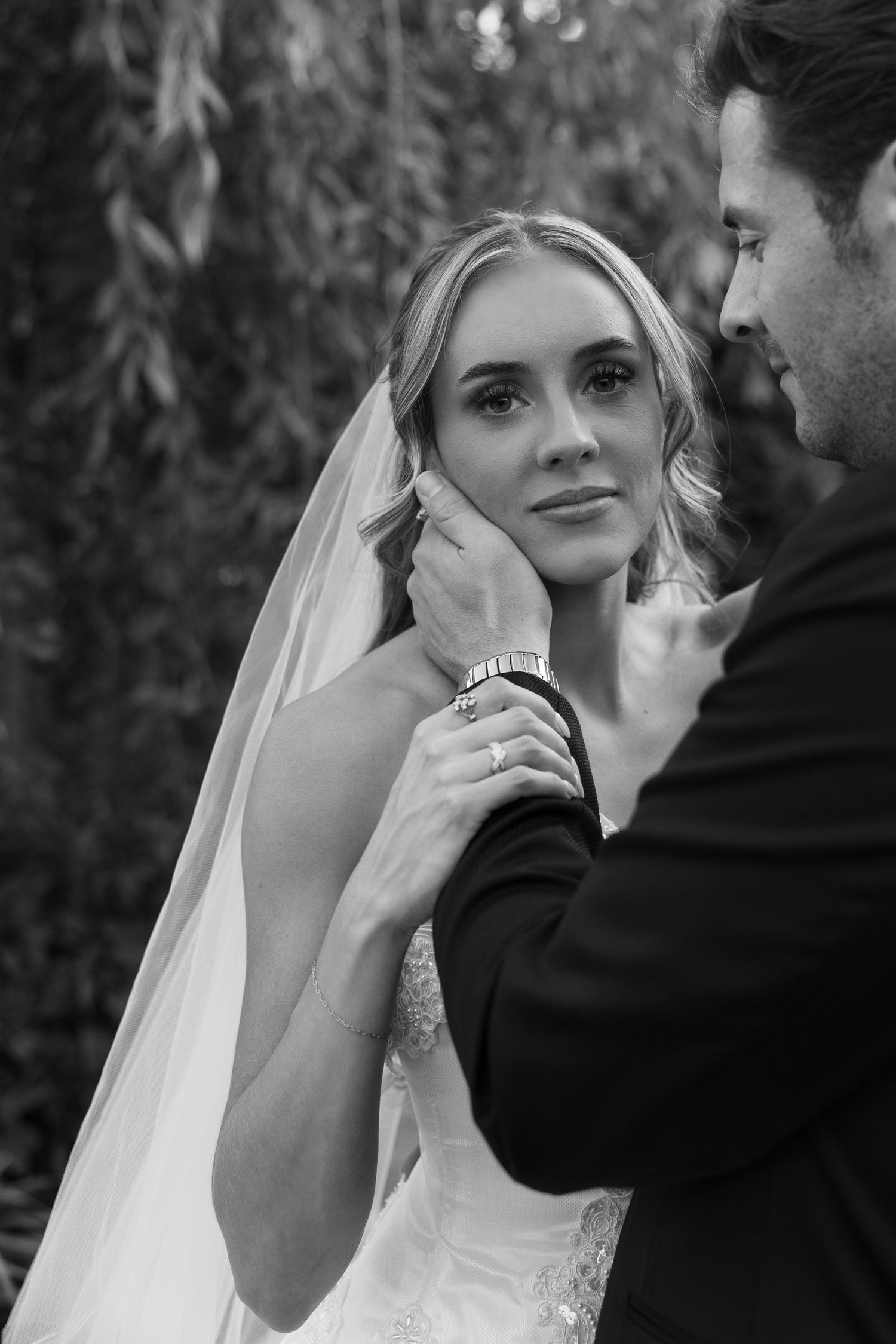 Intimate black and white wedding portraits captured in natural outdoor setting.