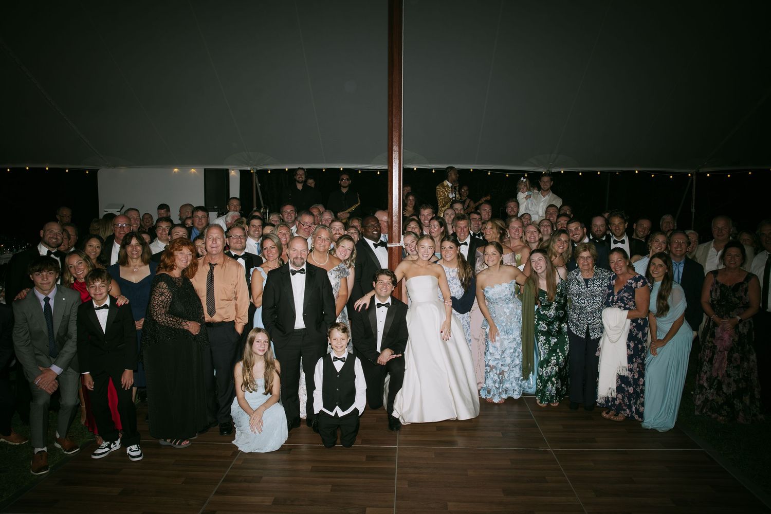 Large group of wedding guests gathered for a formal evening celebration.