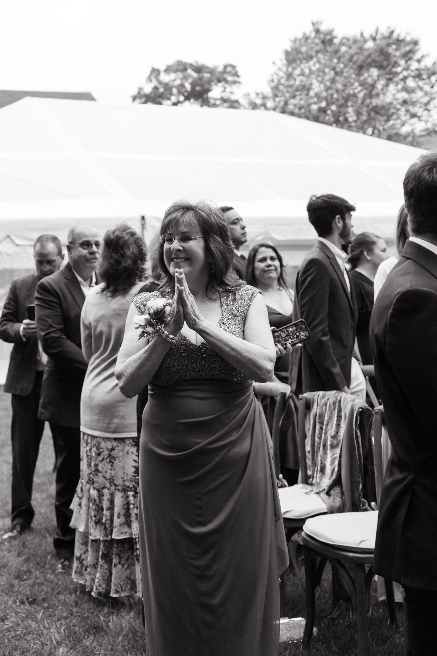 Wedding guests mingling at an outdoor reception in black and white.