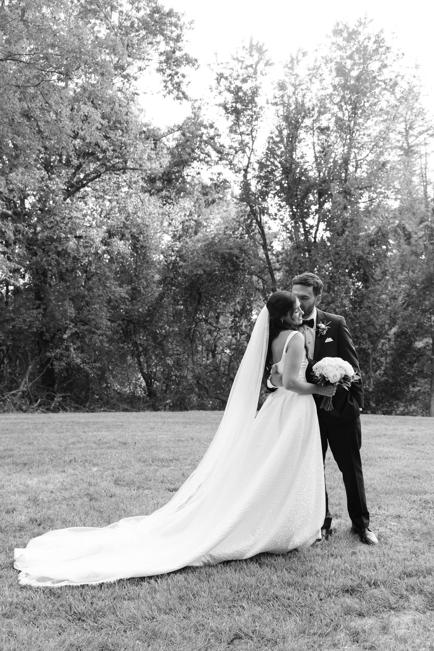 Black and white wedding photos showing a couple in formal attire on a grassy field.