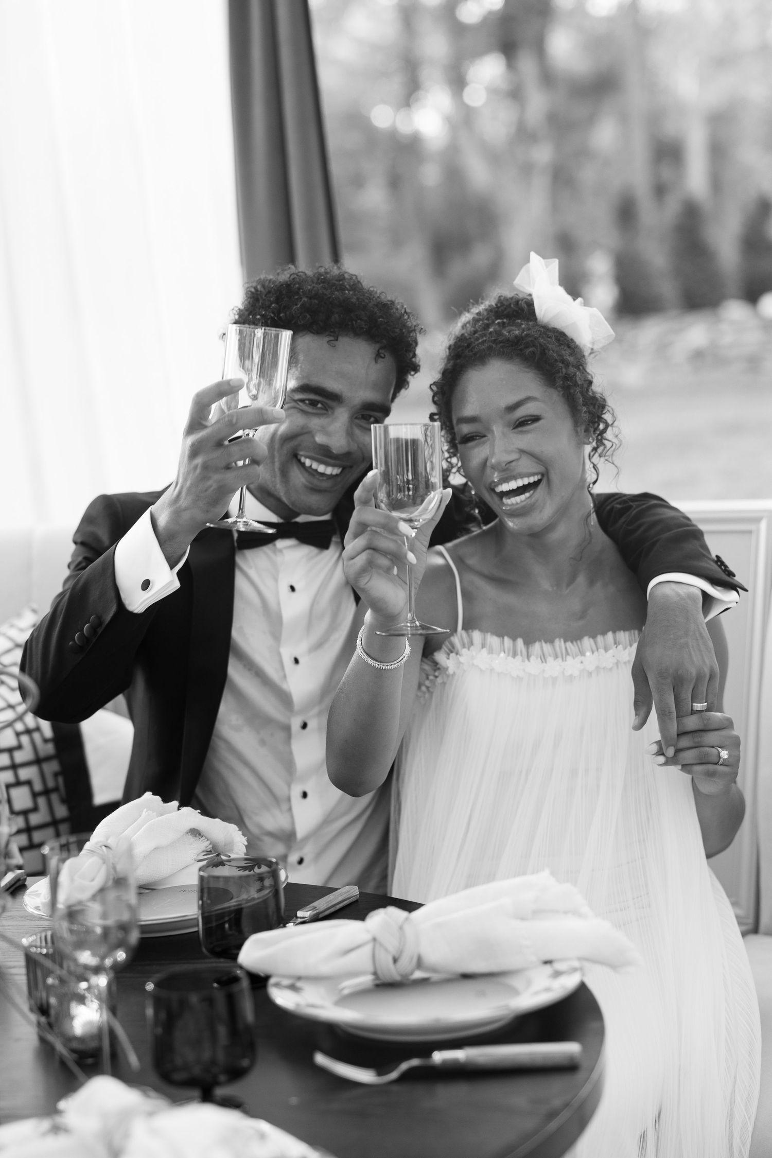 Wedding couple shares joyful laughter during their reception celebration.