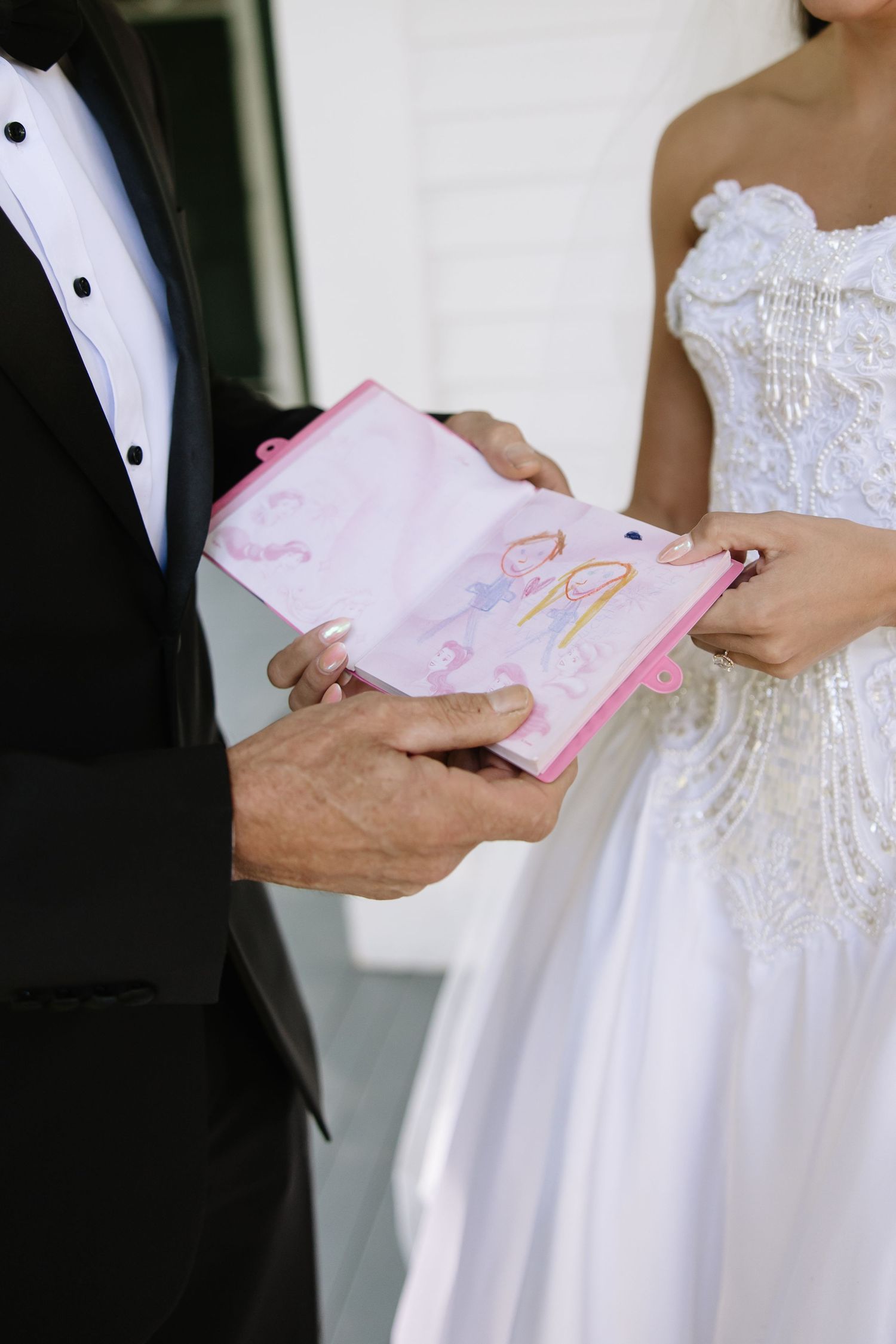 Close-up of couple exchanging written vows or letters during wedding ceremony.