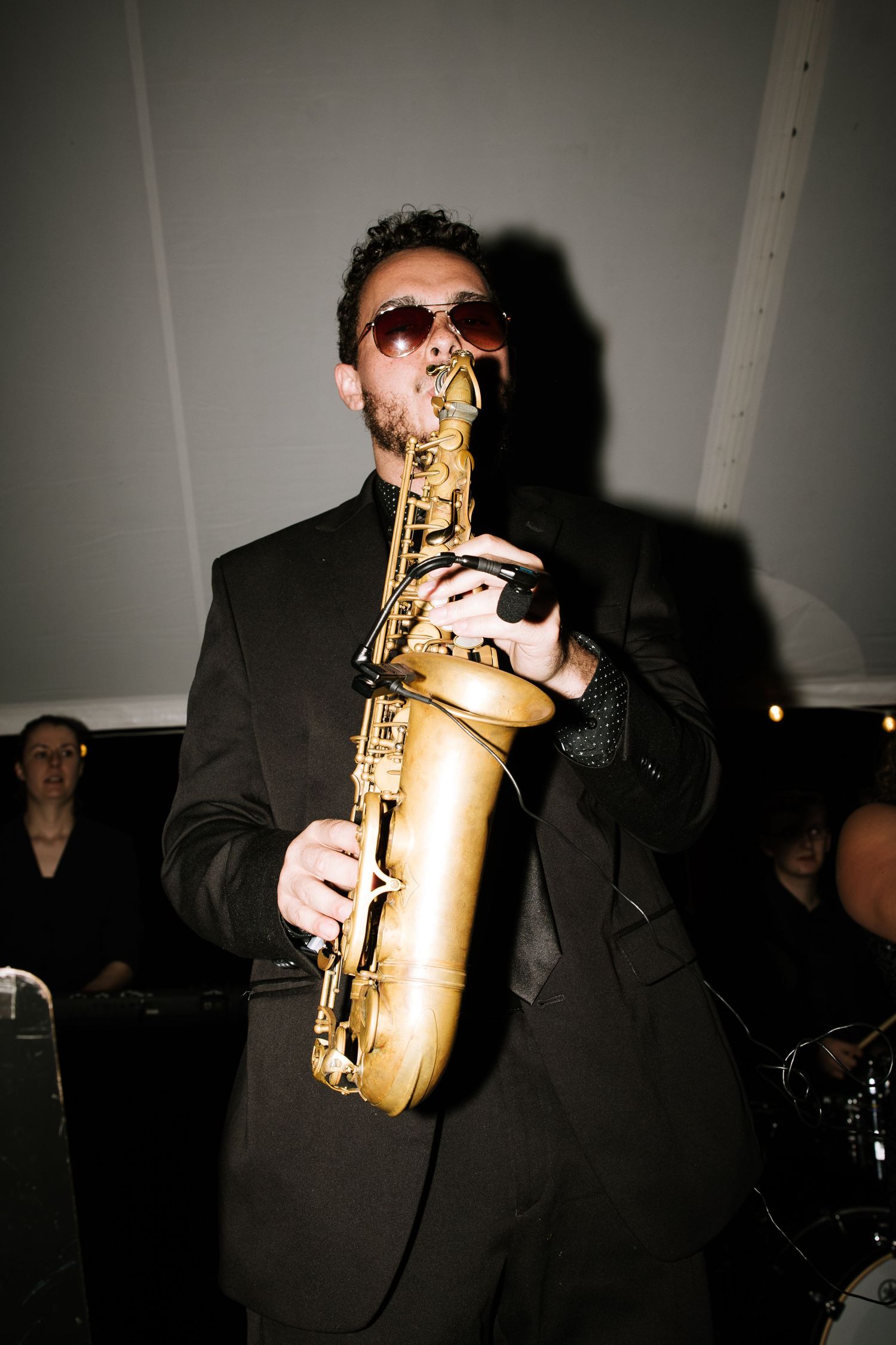 Saxophone player performing in formal attire at an evening event.
