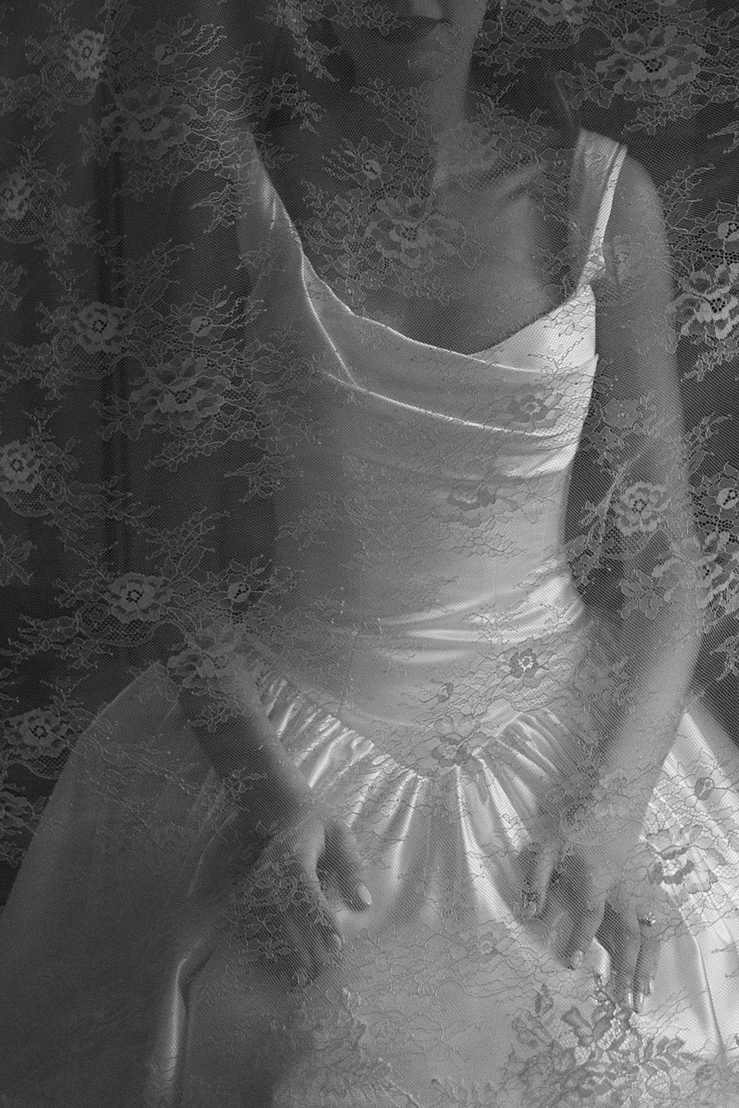 Close-up details of a white wedding dress showing intricate lace and beading patterns.