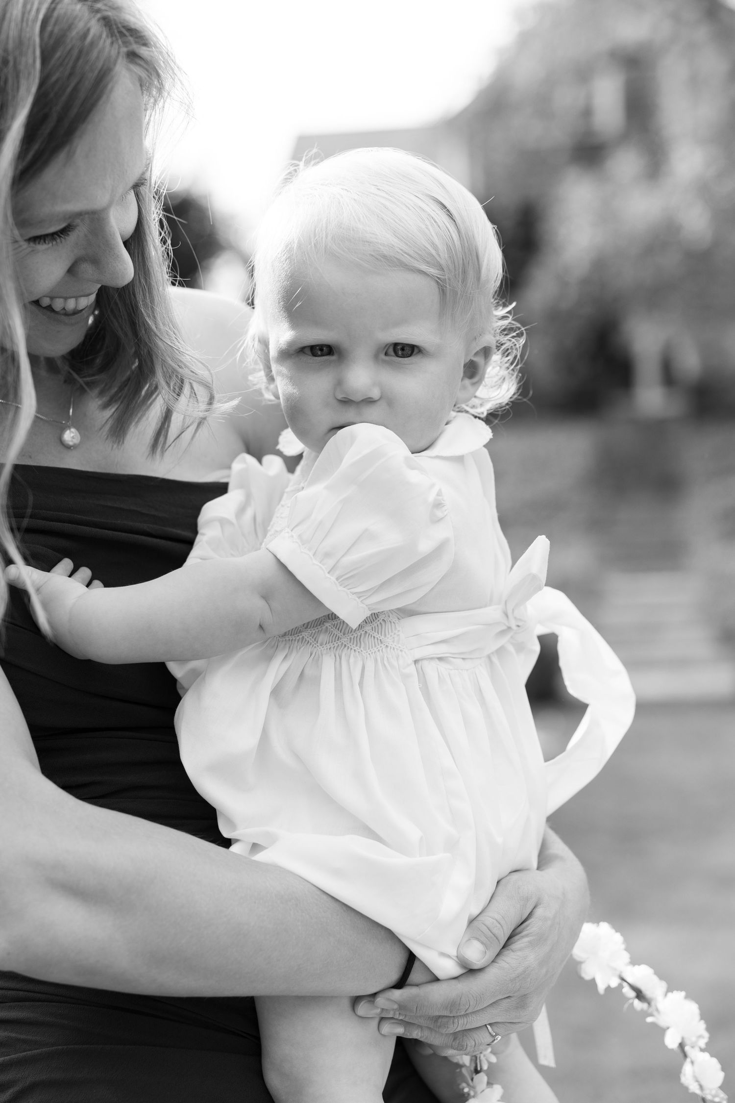 Sweet candid moment in black and white with baby in white dress.