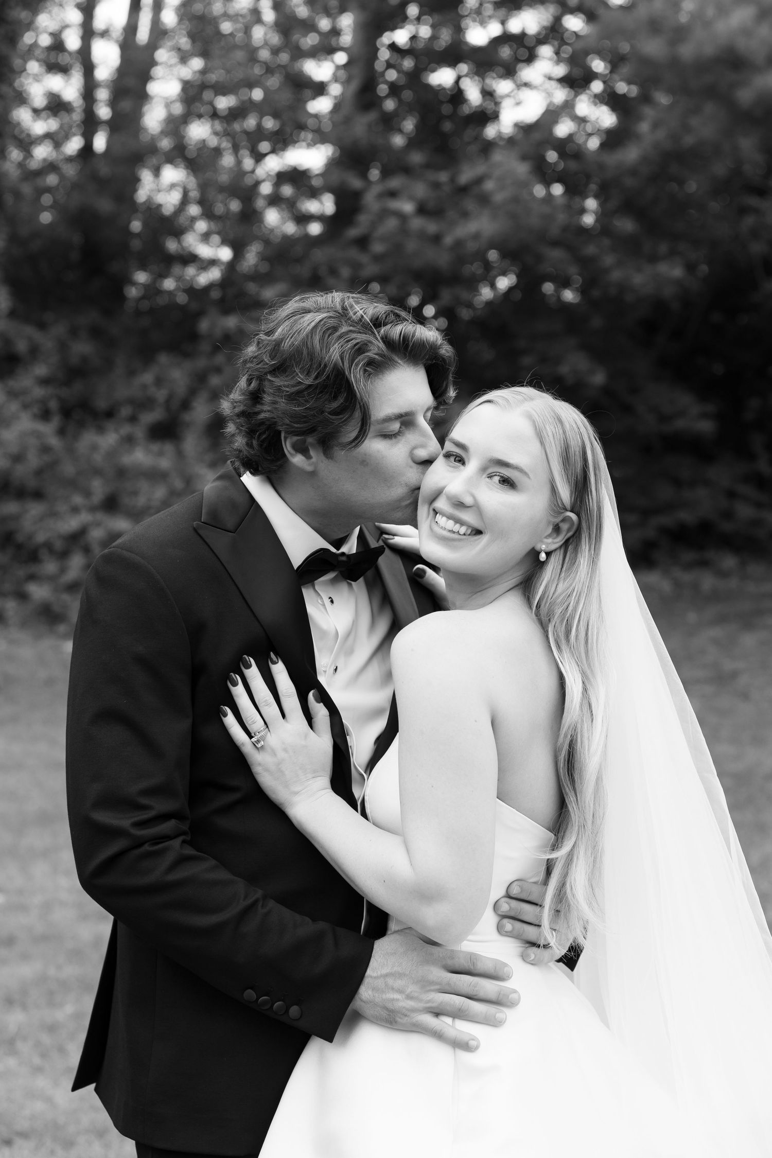 Black and white romantic wedding photos showing tender moments in an outdoor setting.