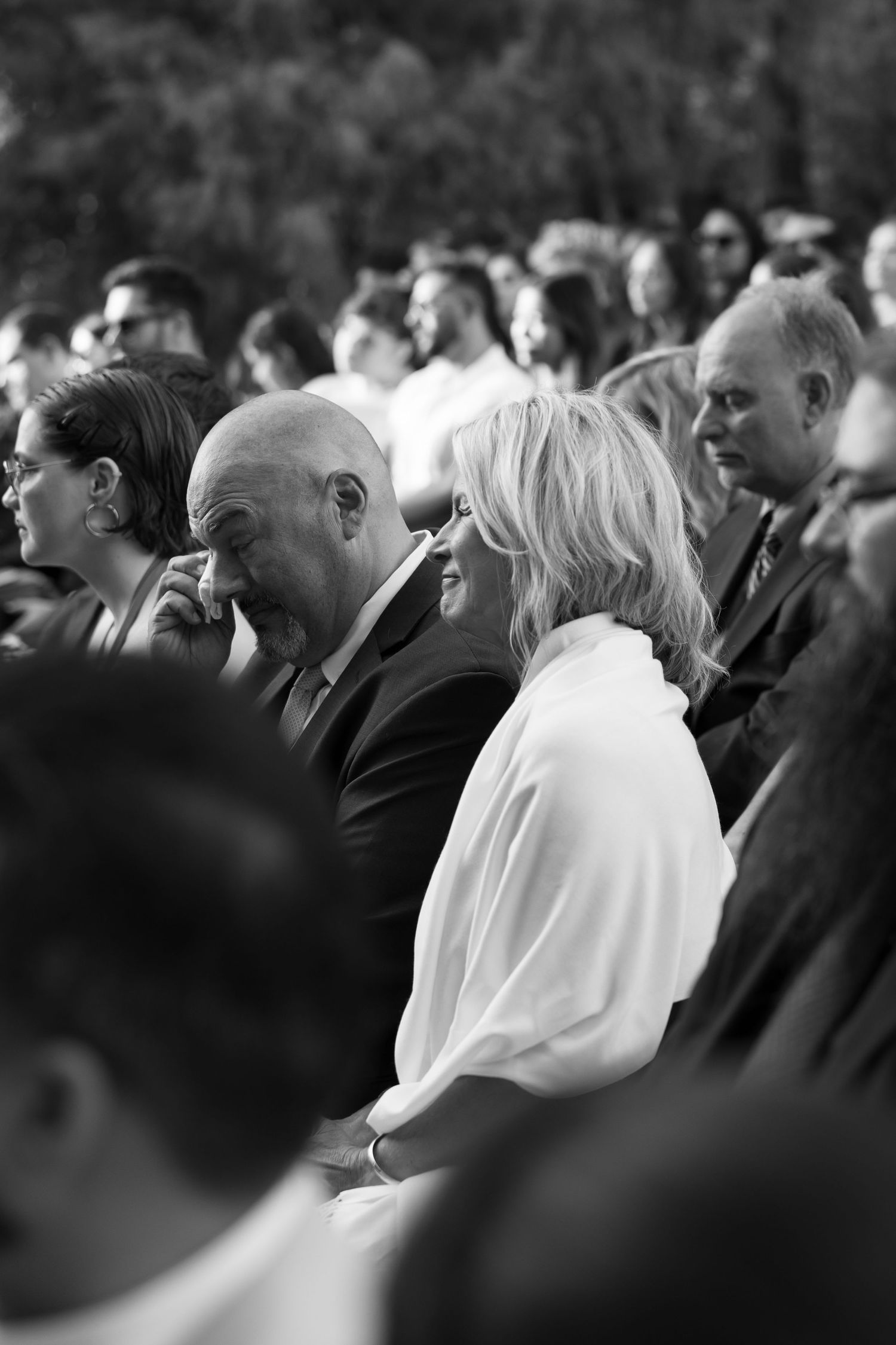 Black and white photo of wedding guests seated during ceremony.