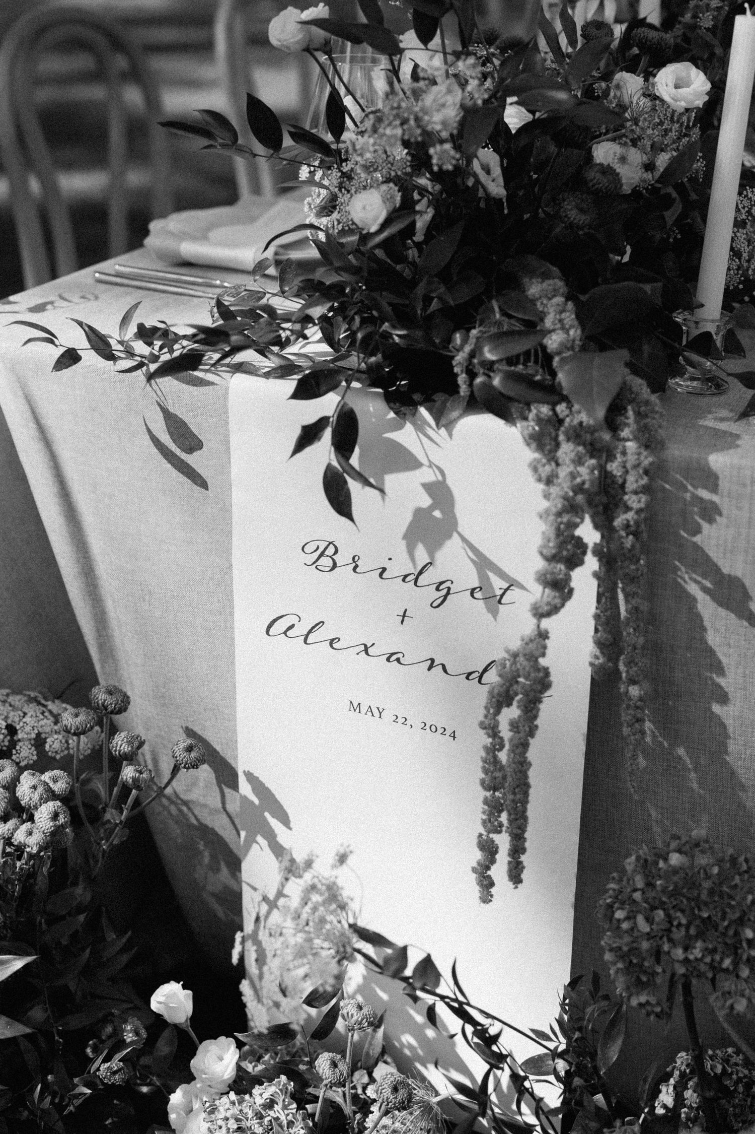 Black and white photo of elegant wedding name cards with floral decorations.