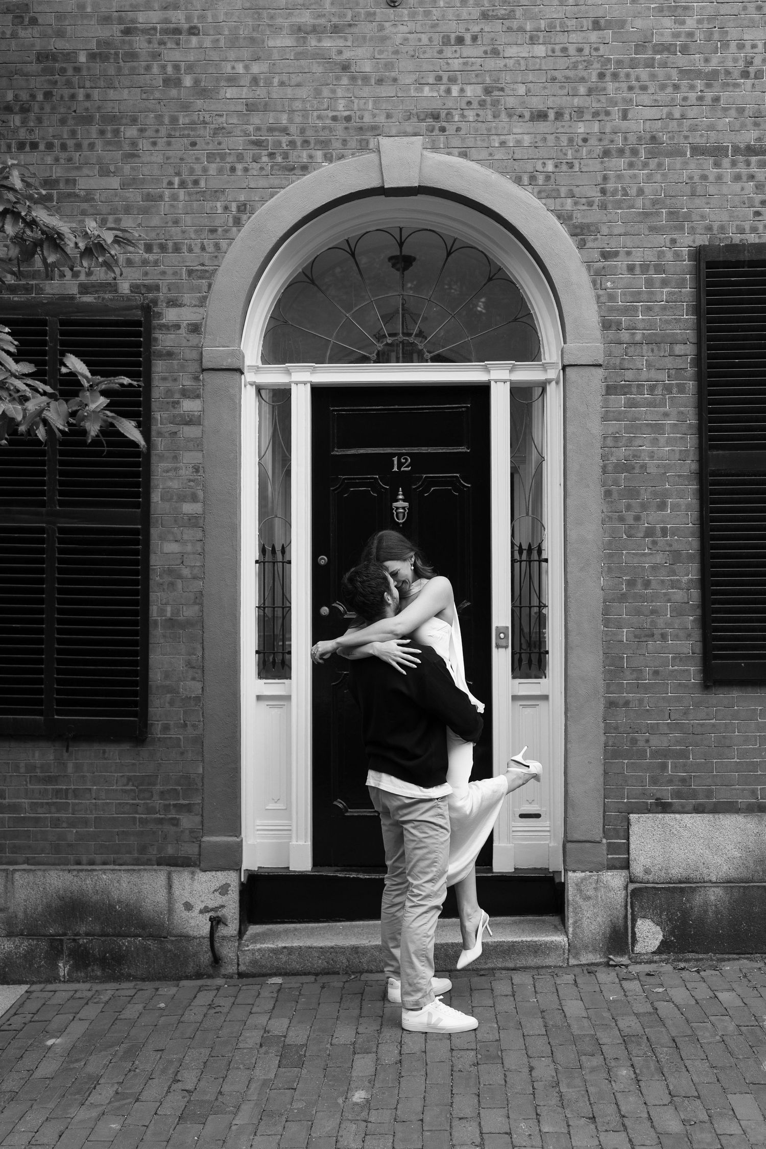 Black and white sequence of dance moves in front of classic brick doorways.