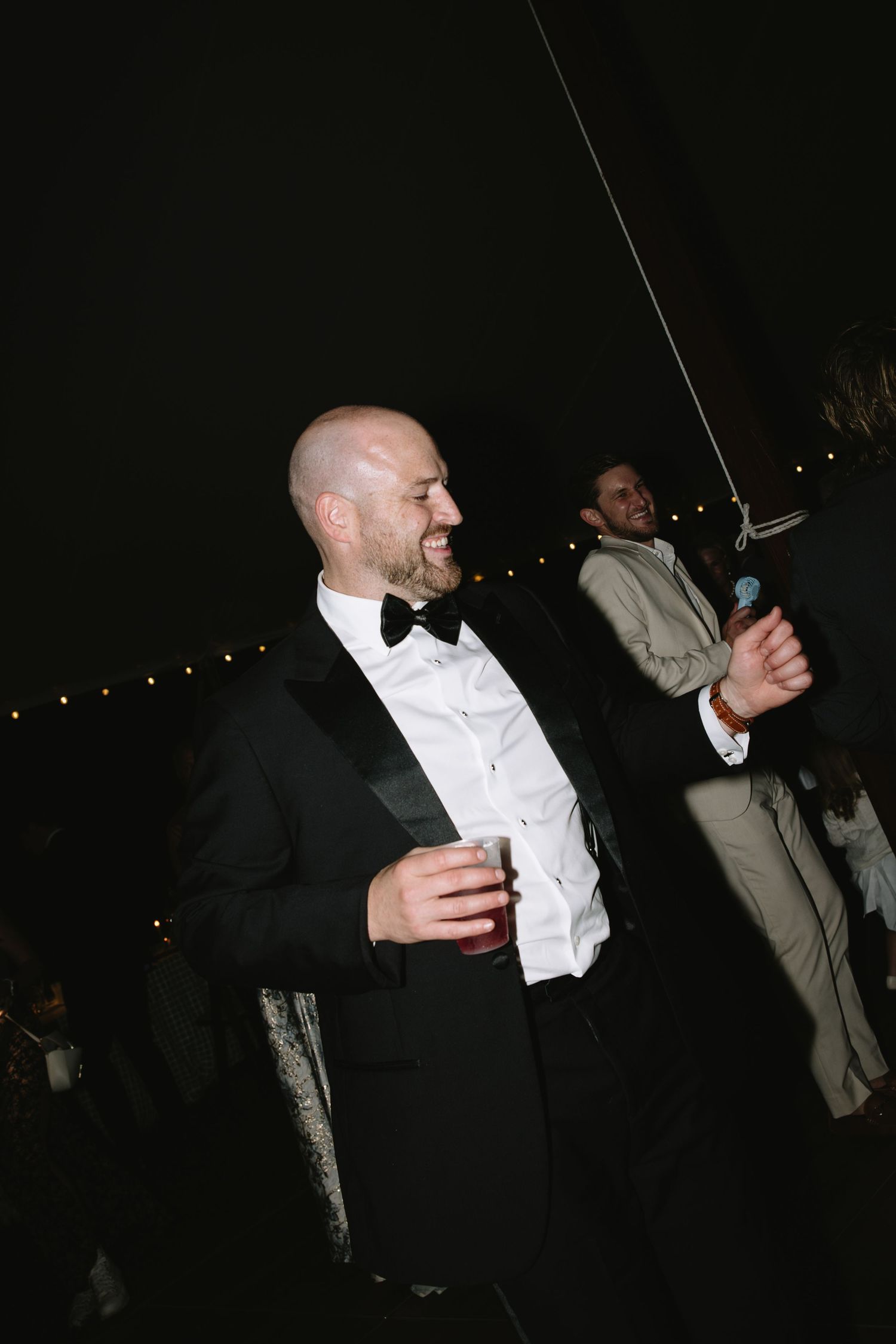 Wedding guests in formal attire dancing and celebrating at a reception.