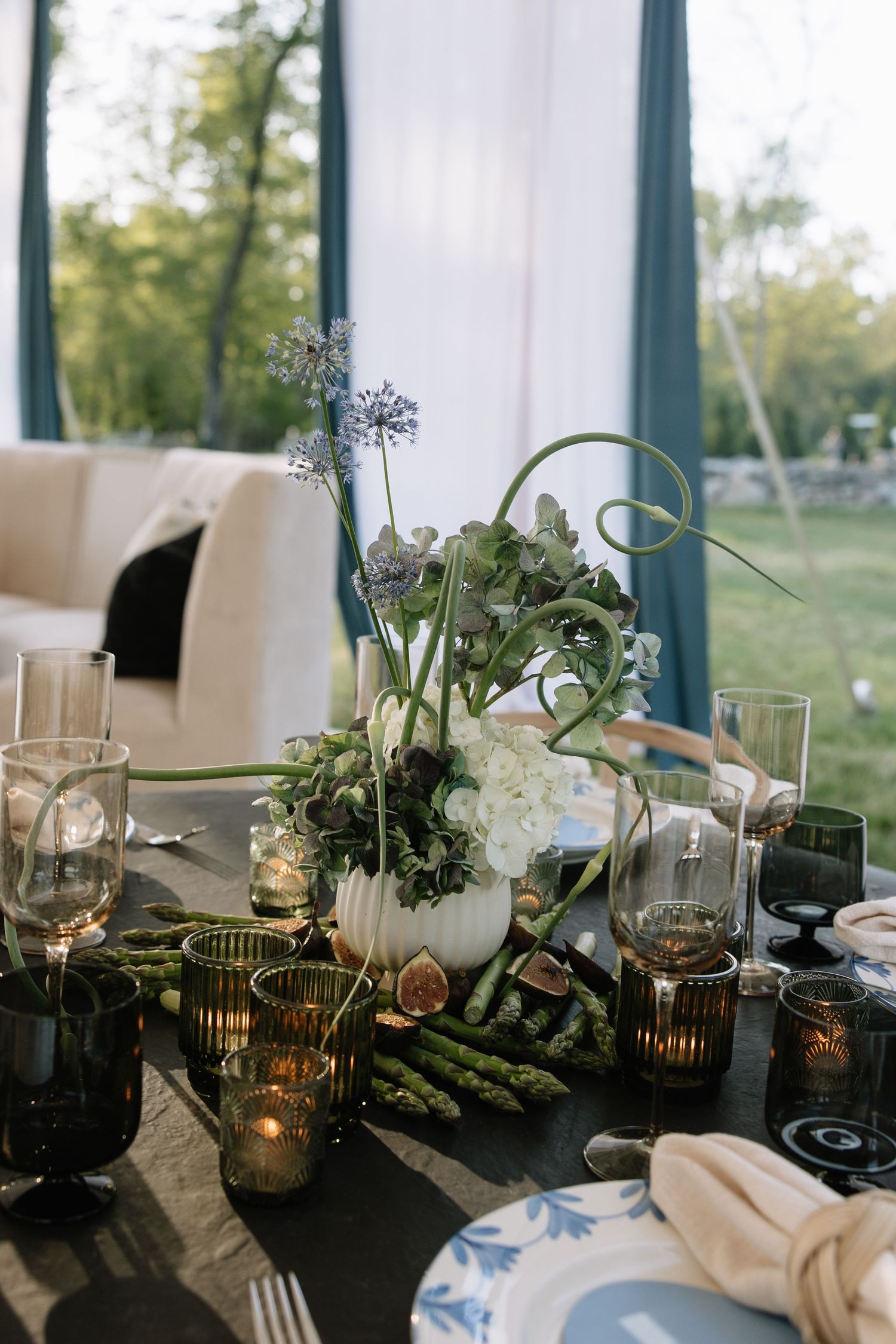 Elegant wedding table setting with greenery, candles, and white floral centerpieces.