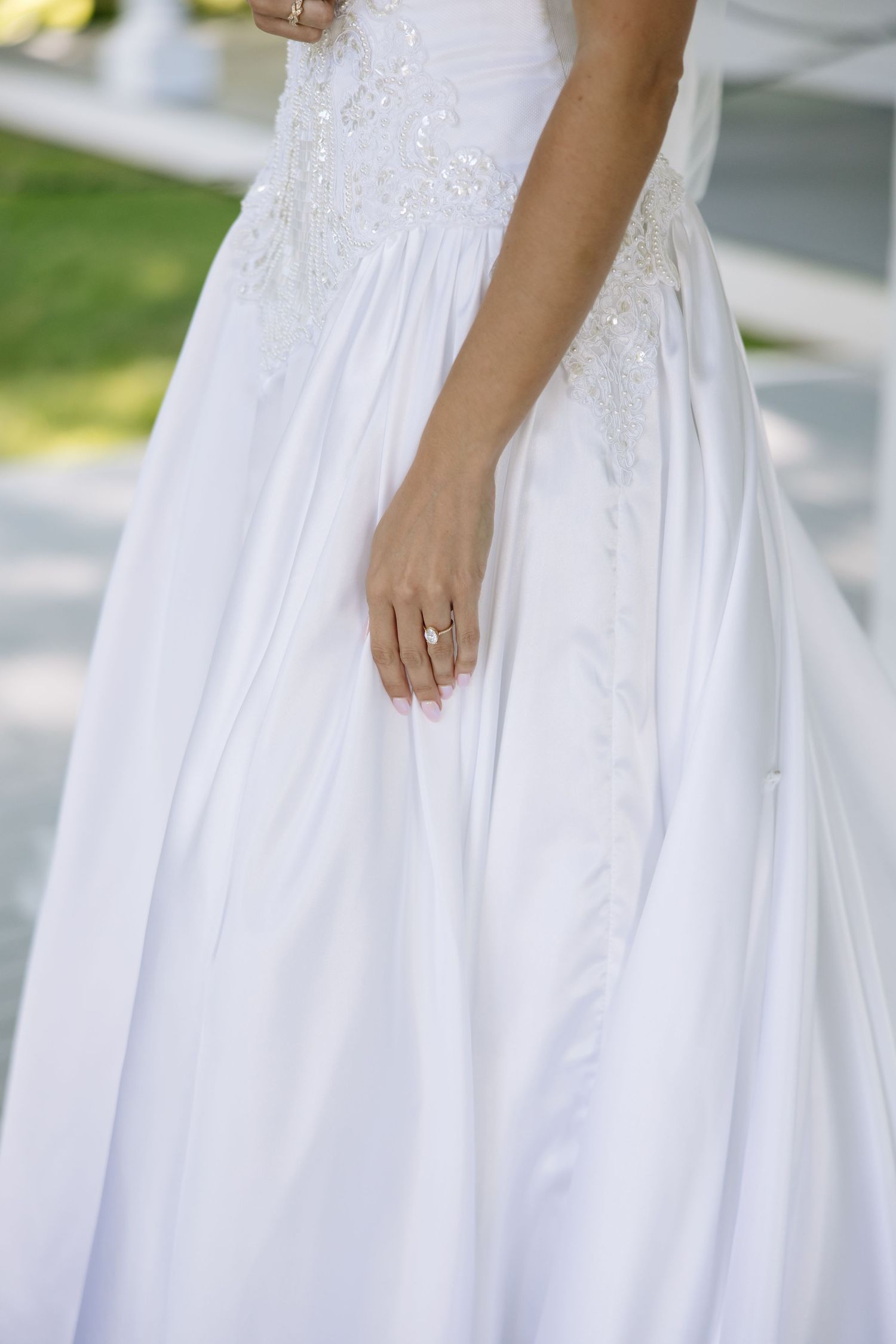 Detail shots of white wedding dress with intricate lace and beading in natural light.