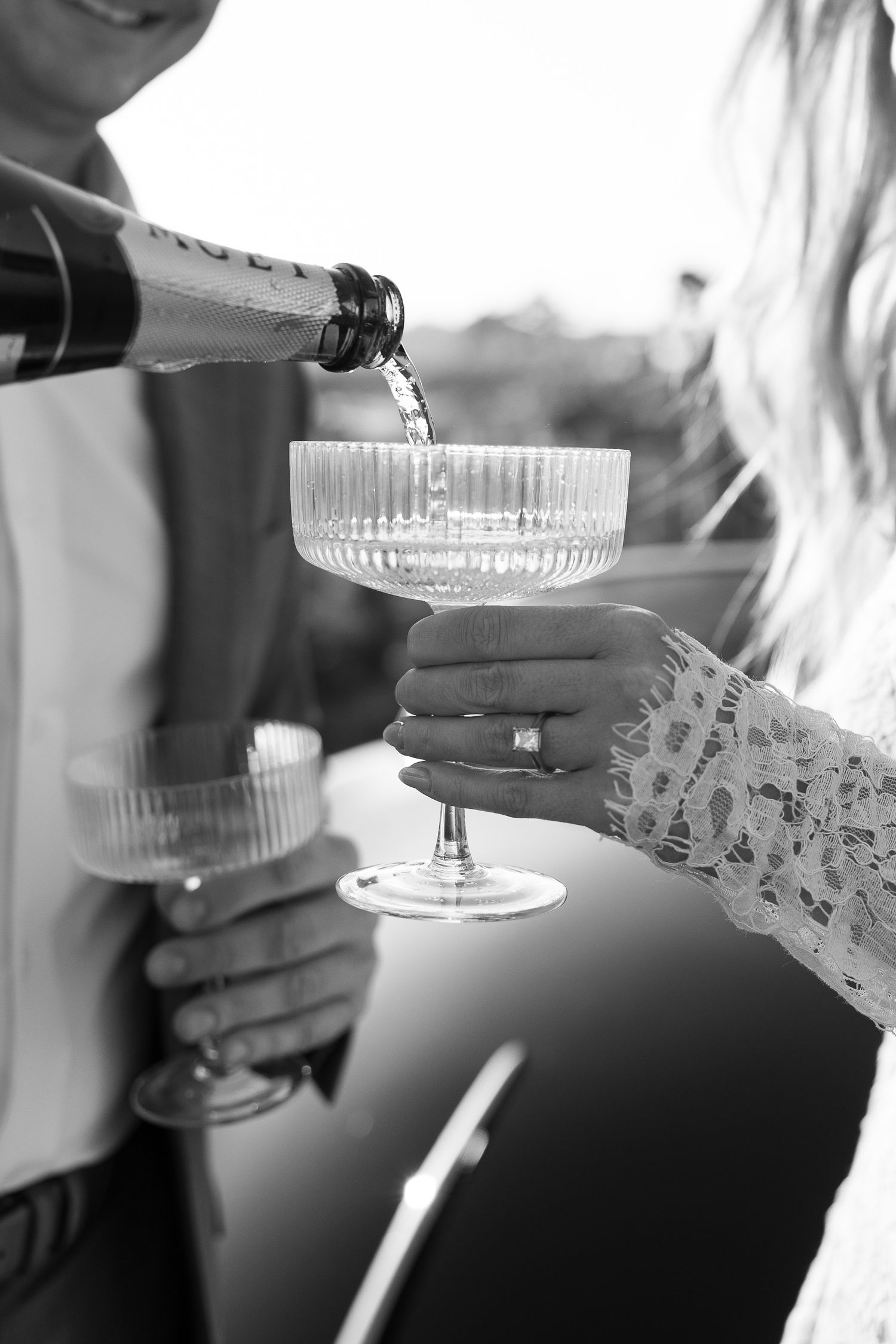 Champagne being poured into an elegant crystal coupe glass at a celebration.