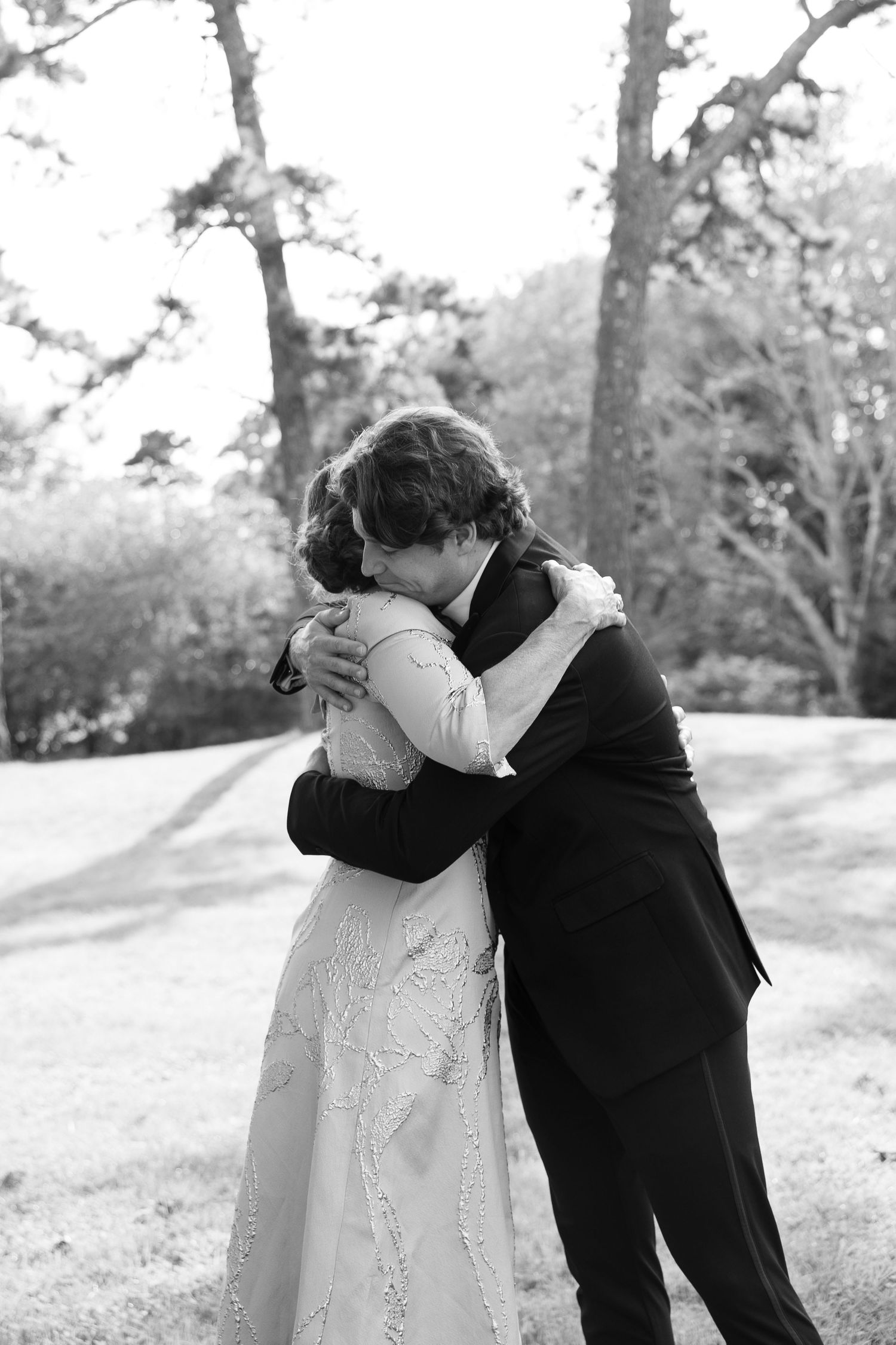 Black and white romantic wedding moment captured outdoors.