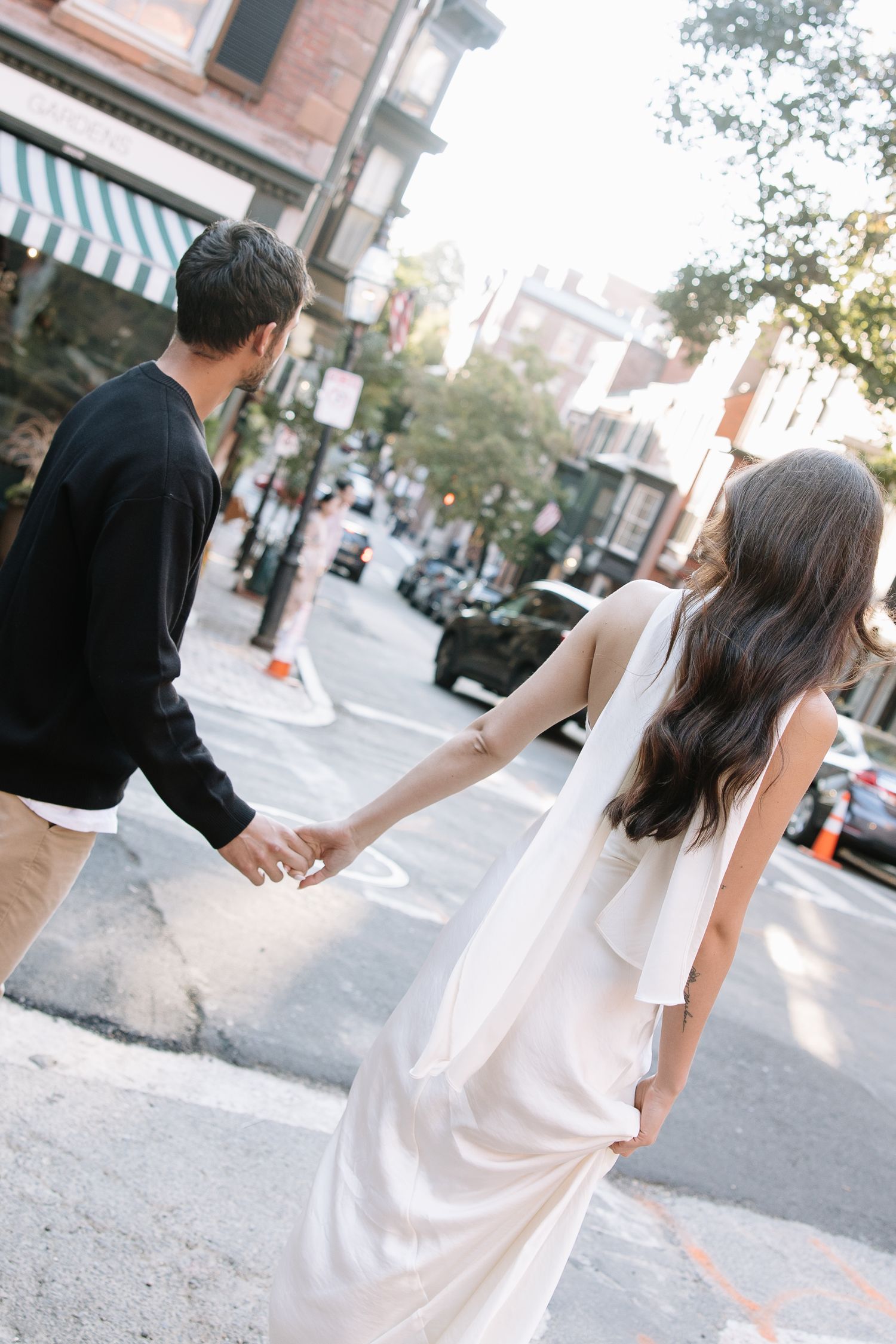 Couple walking together on a sunny urban street.