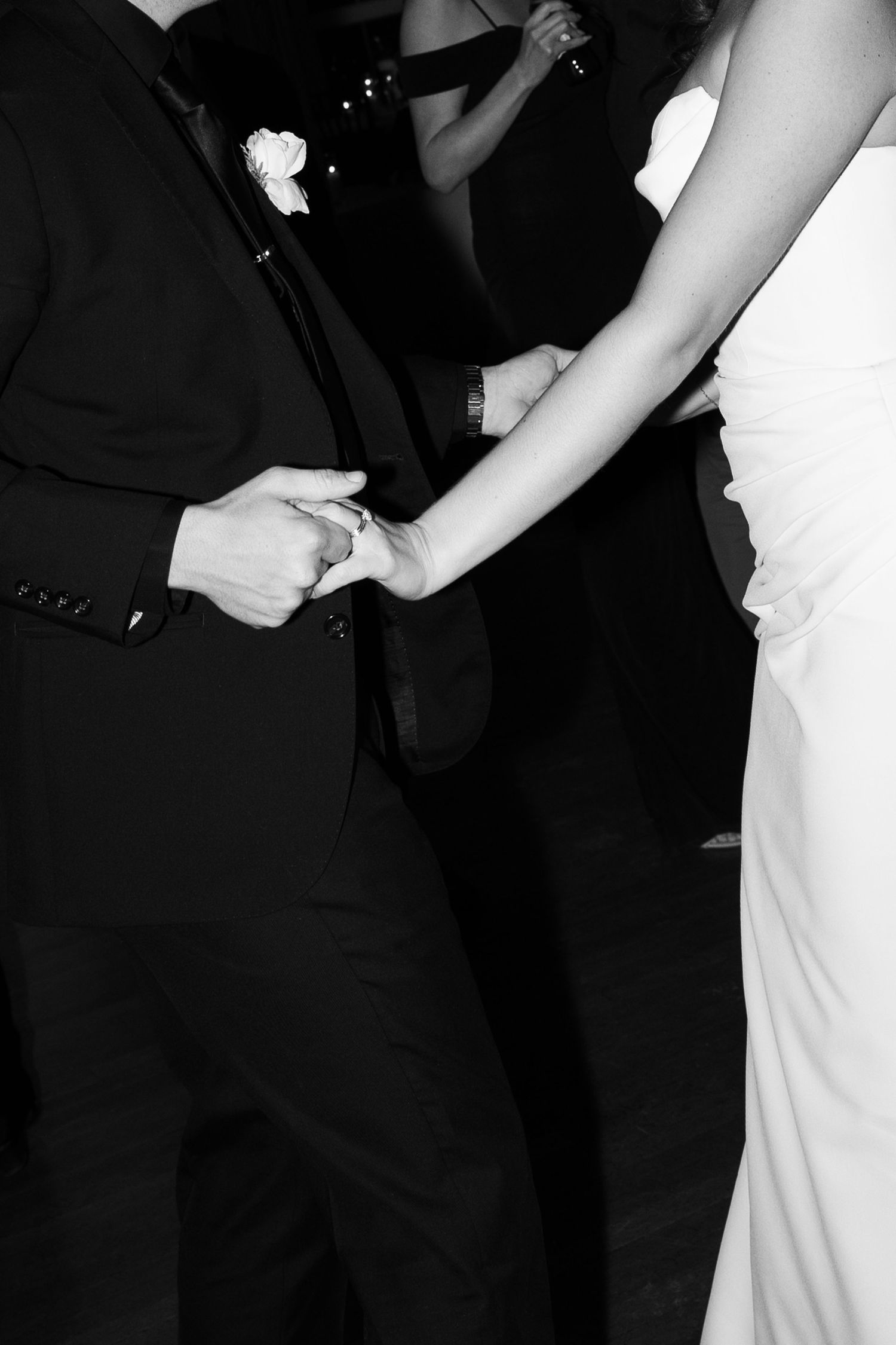 Close-up black and white photos of a couple dancing at their wedding reception.