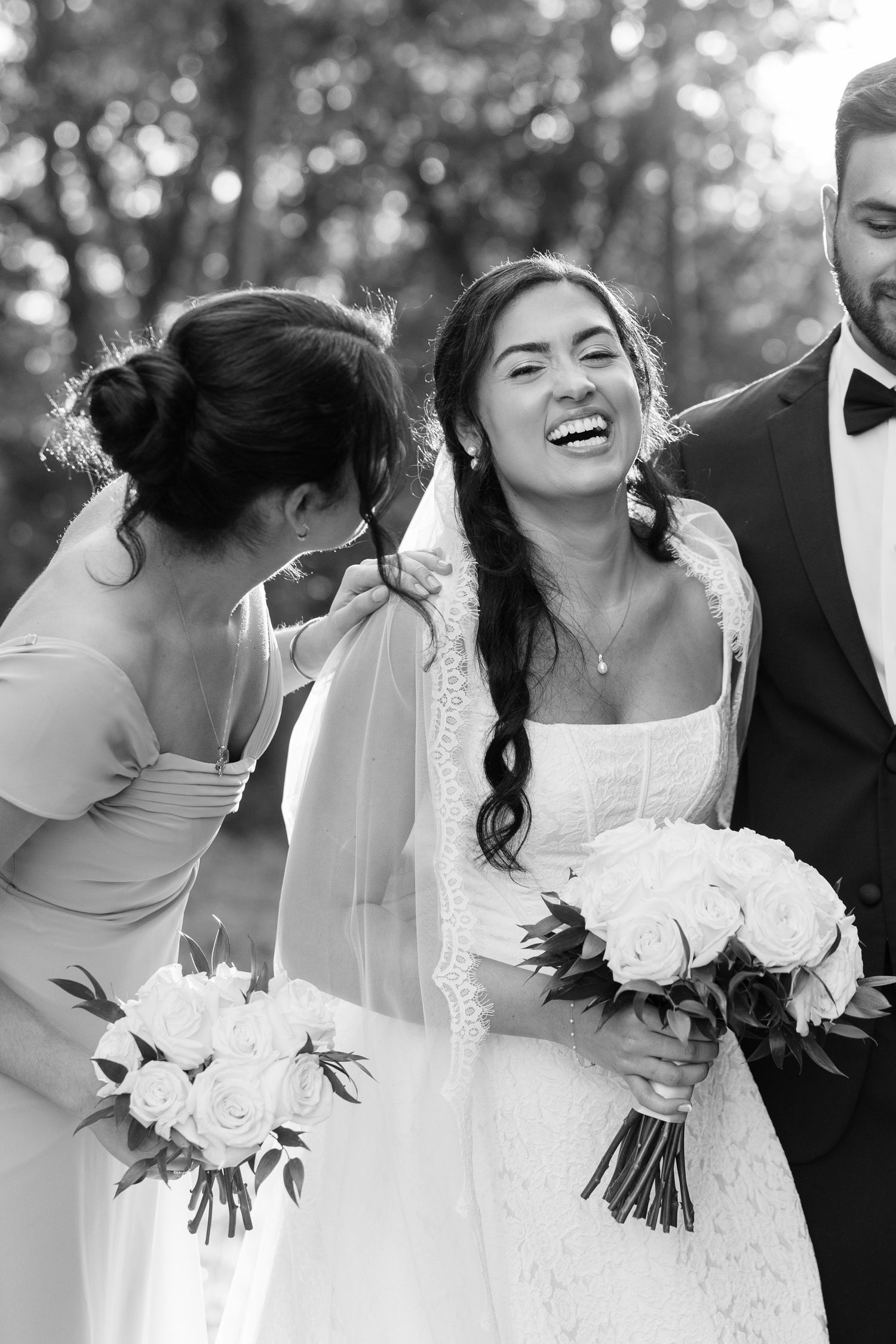 Candid black and white wedding party photos showing joyful laughter and celebration.
