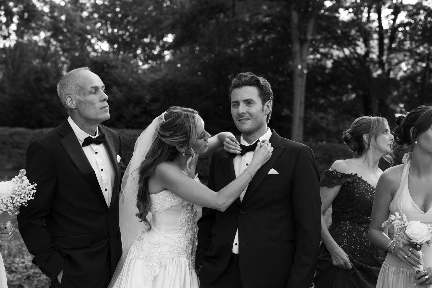 Black and white candid moments captured between wedding party members during outdoor photo session.