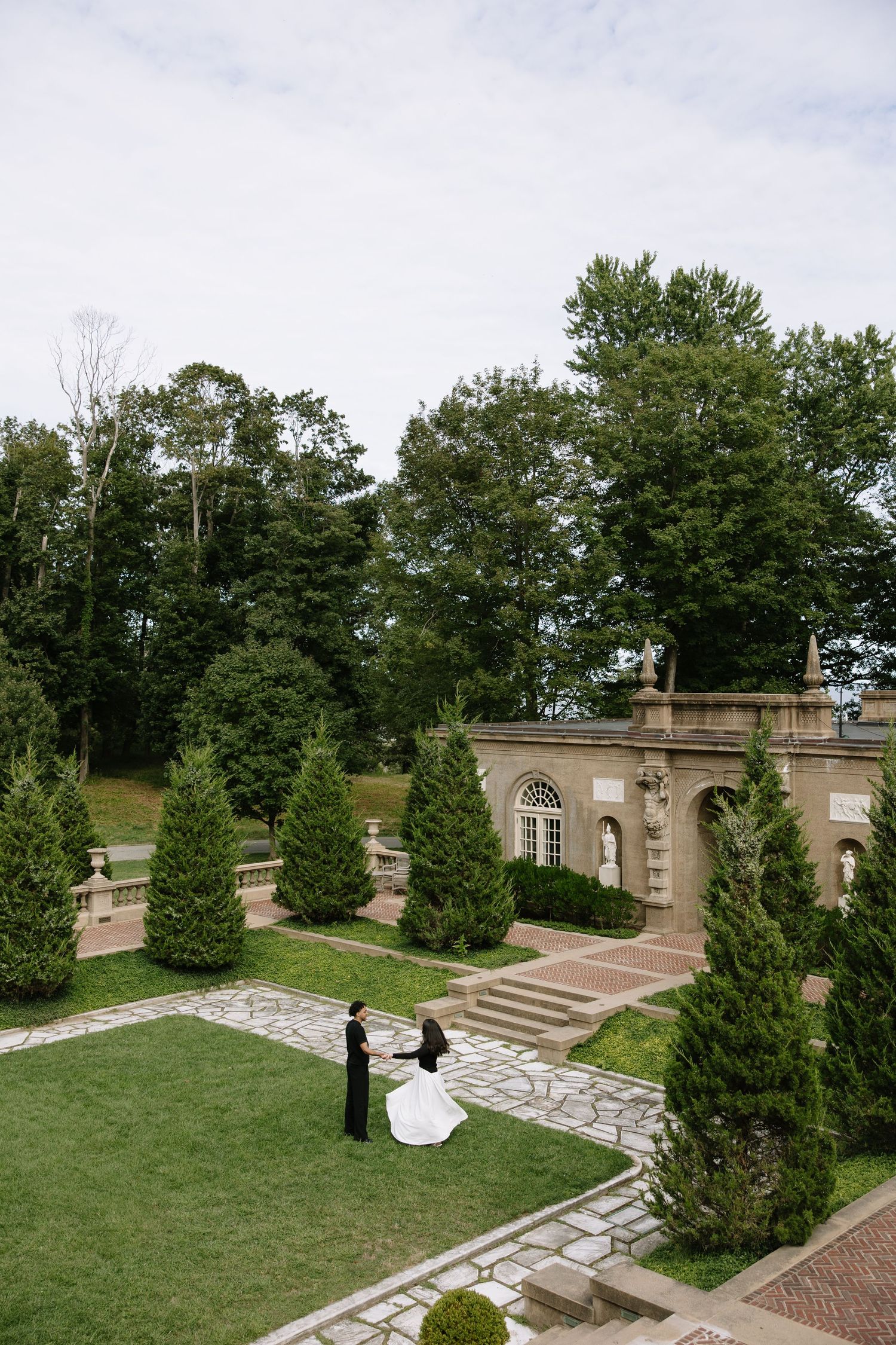 Elegant stone terrace with cypress trees and manicured lawns for wedding photography.
