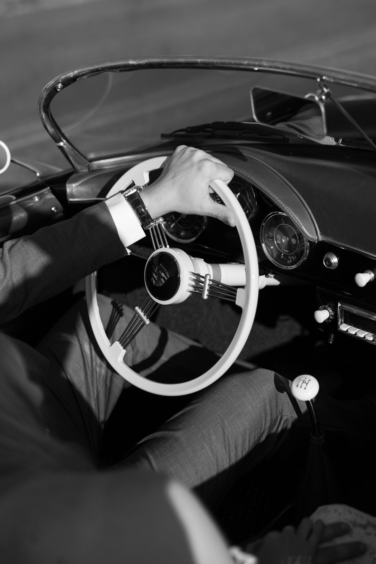 Black and white series showing hands on a vintage car's steering wheel.