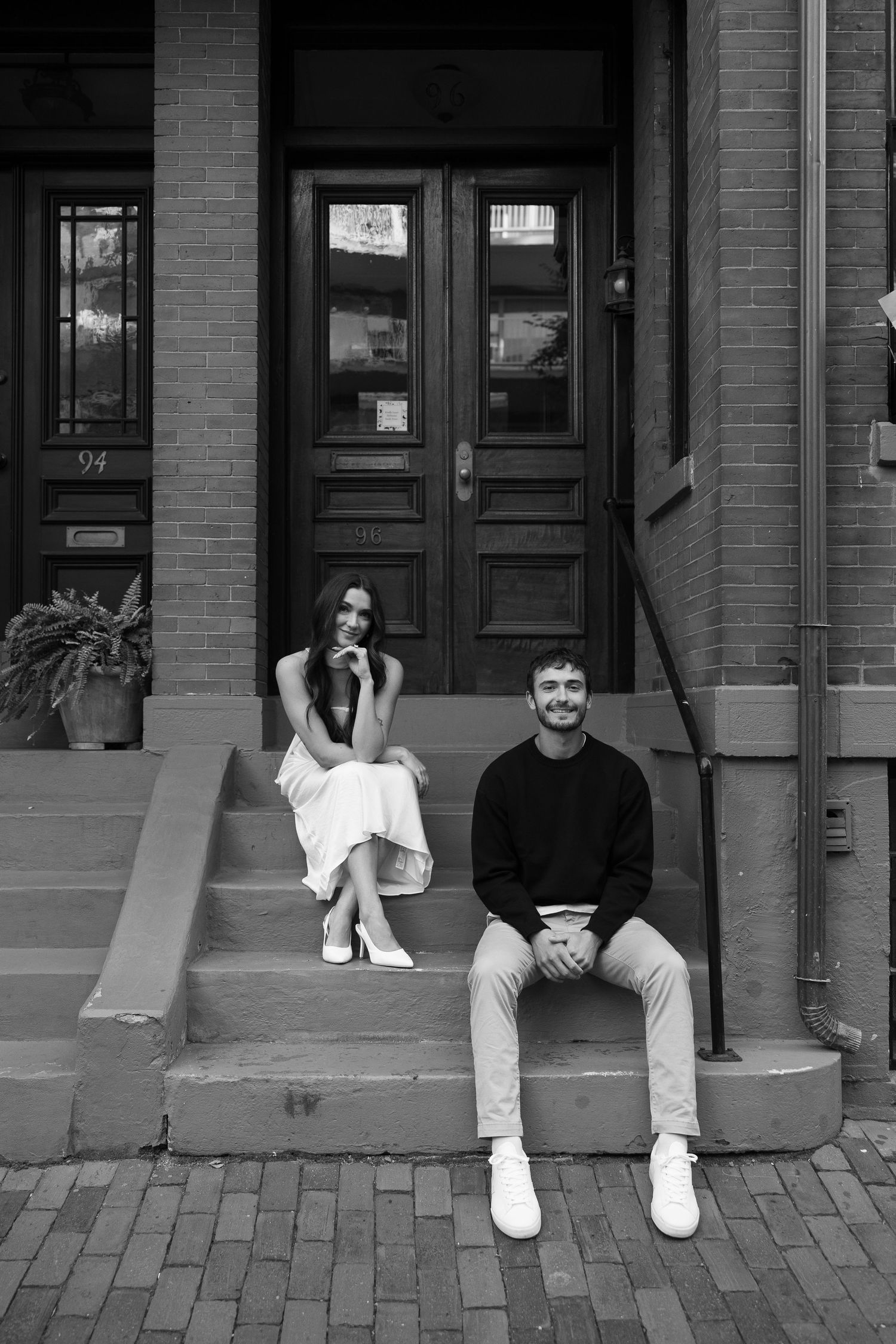 Urban photoshoot sequence on brick steps in black and white.