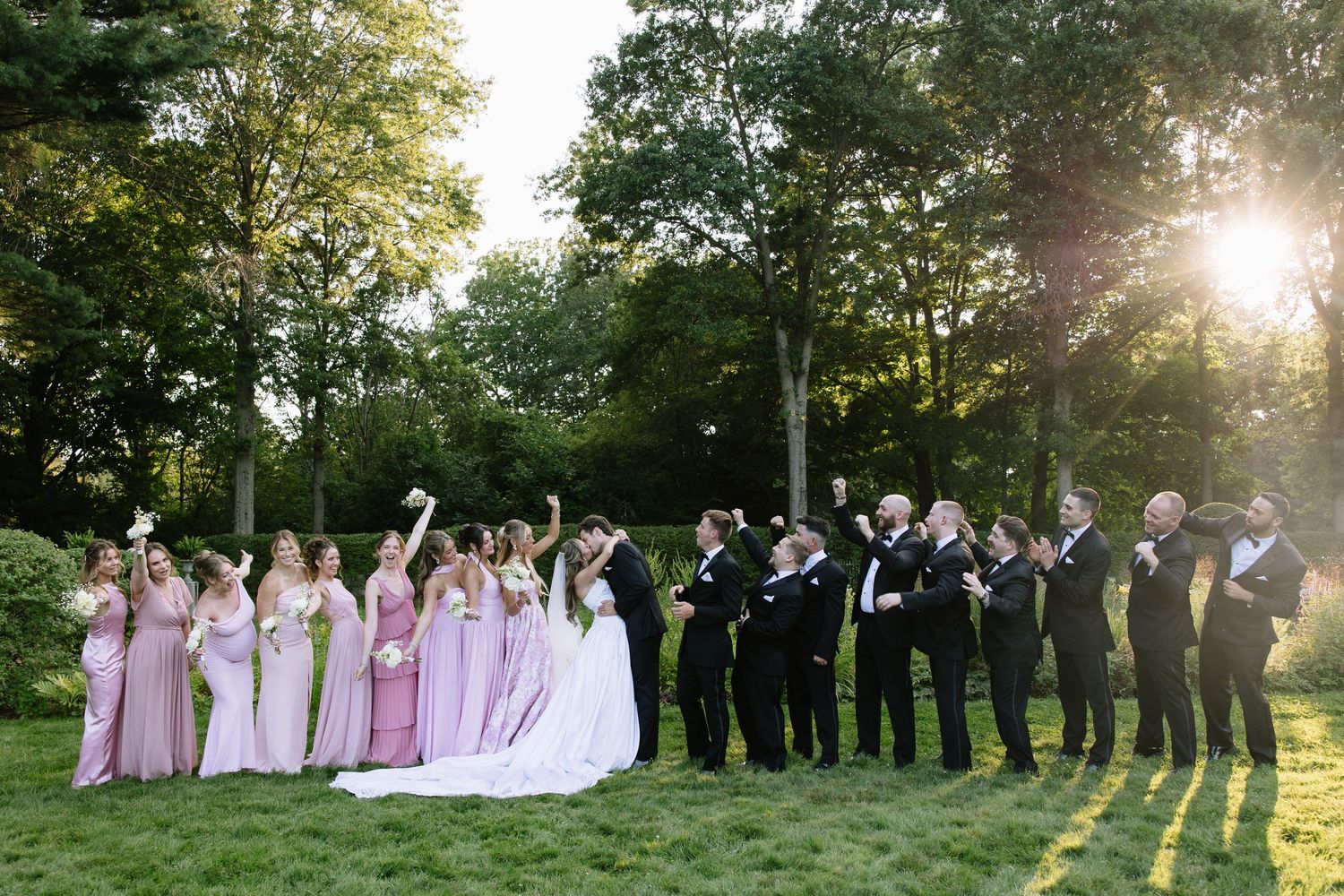 Wedding party group photos taken at golden hour in a scenic garden setting.