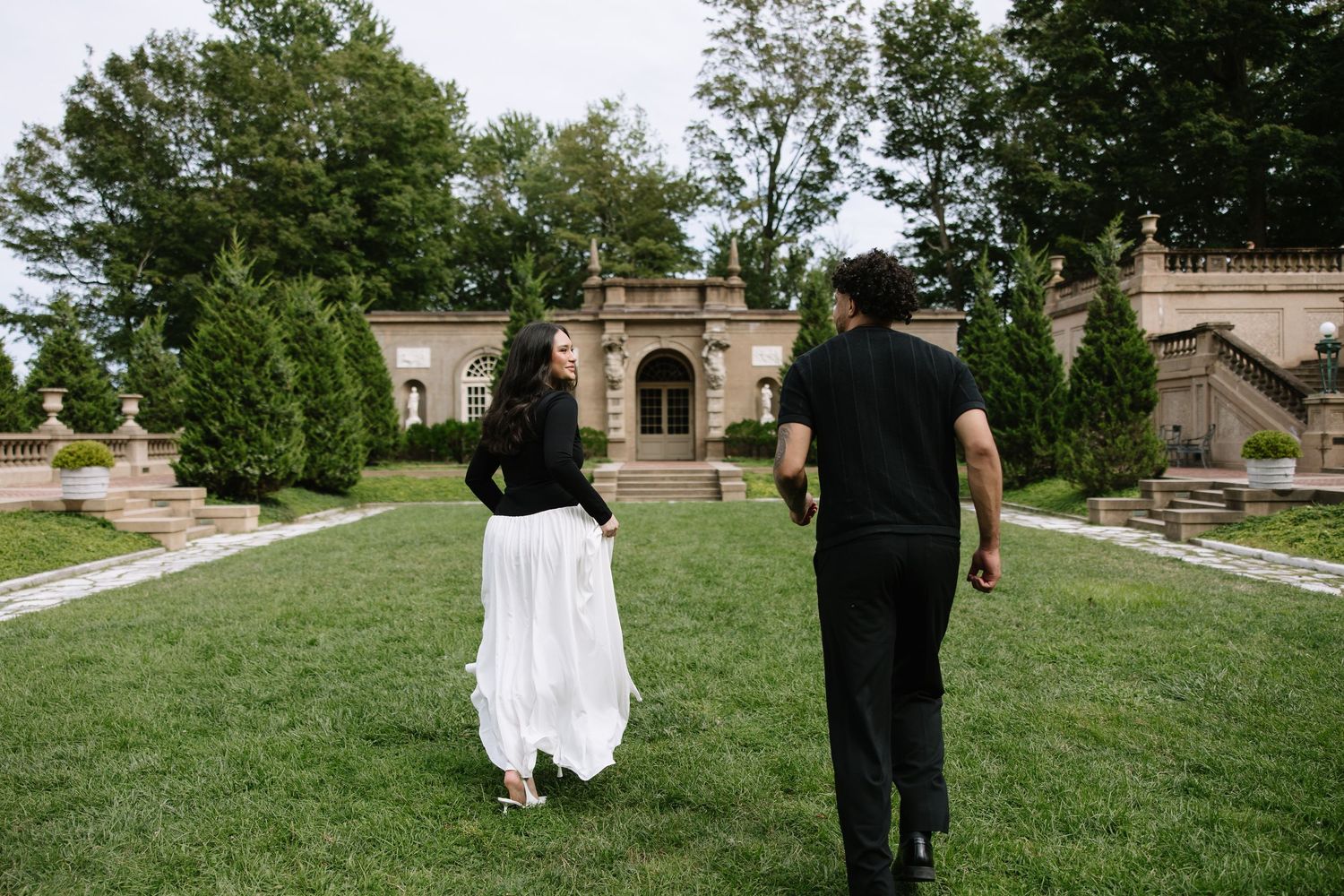 A panoramic view of a manicured lawn and garden path at a historic estate.