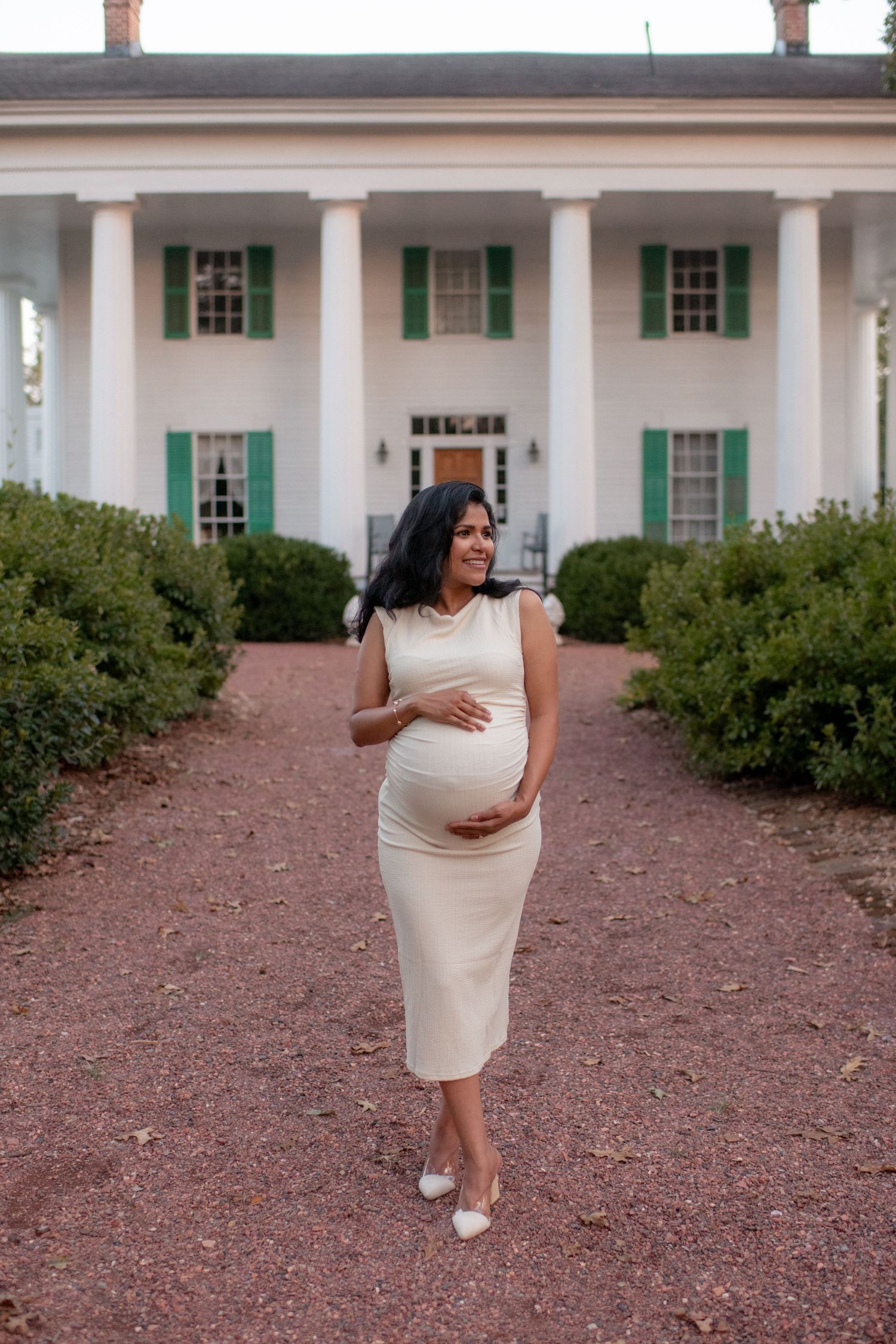 Elegant maternity photos taken in front of historic white columned building.