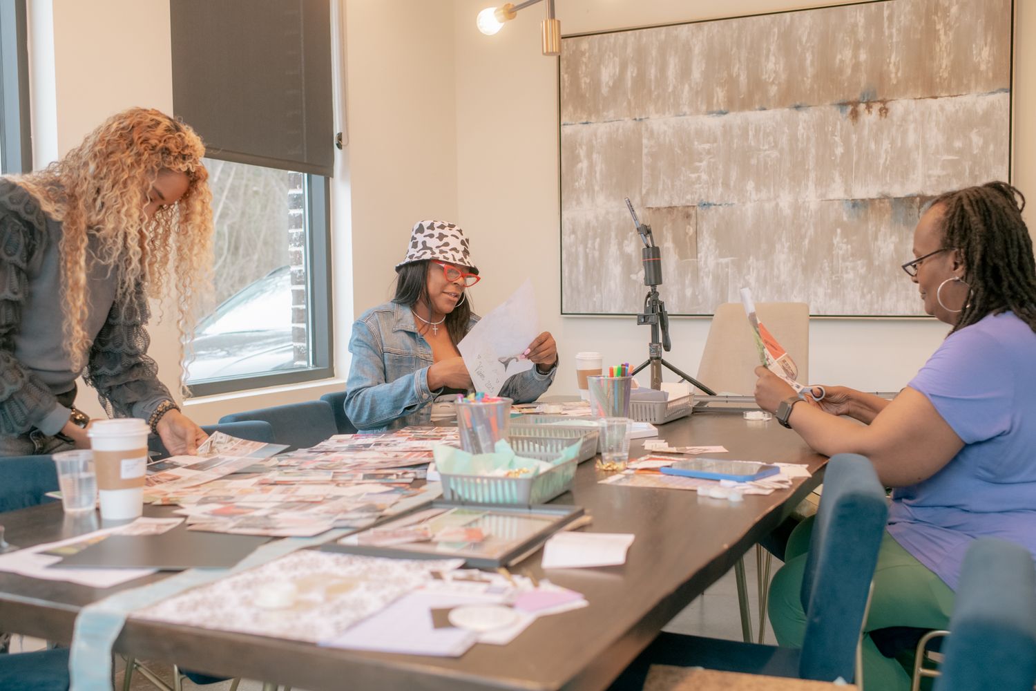 Multiple people seated at tables work together during an indoor workshop or training session.