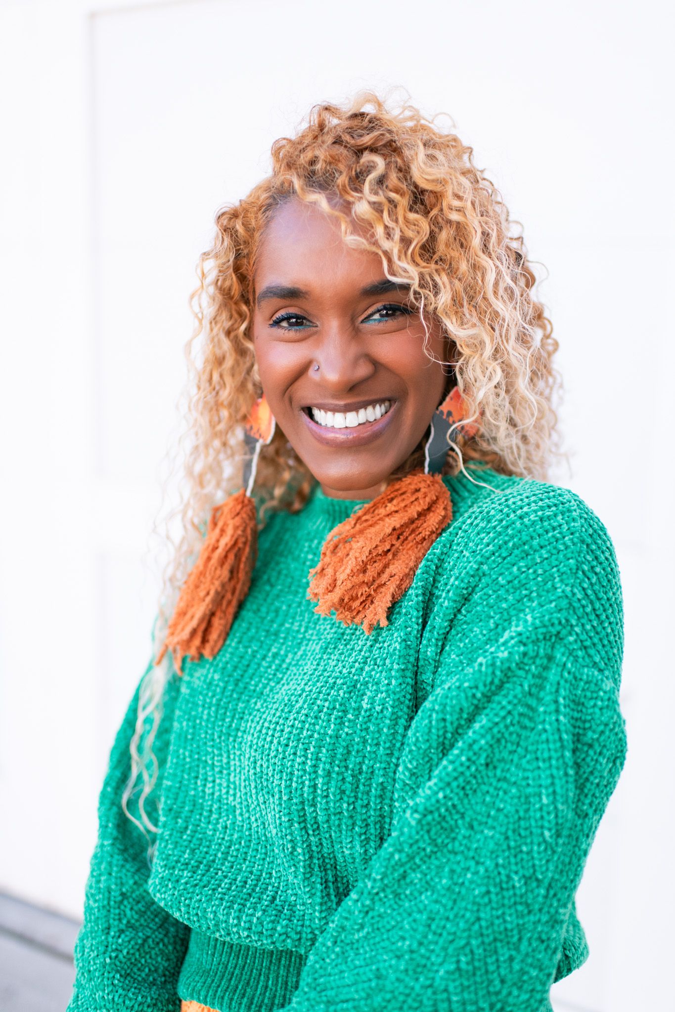 Person wearing bright emerald green sweater poses against white background.