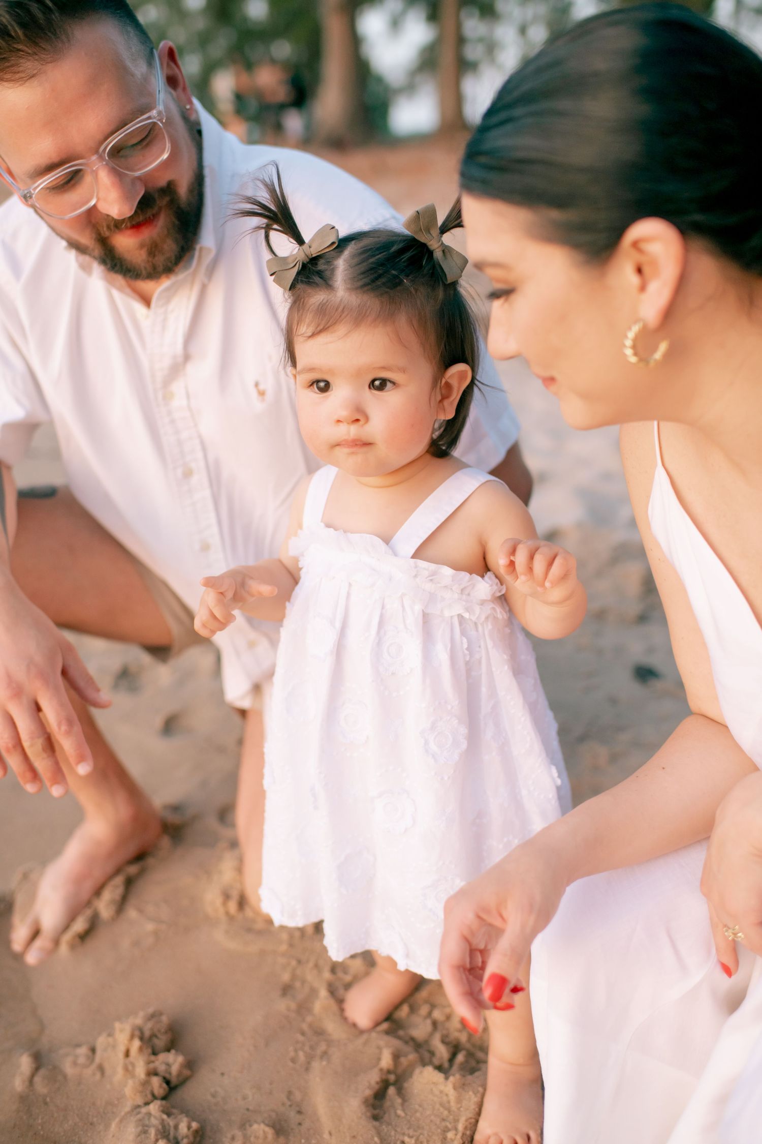 Family plays in the sand together during a beach photoshoot.