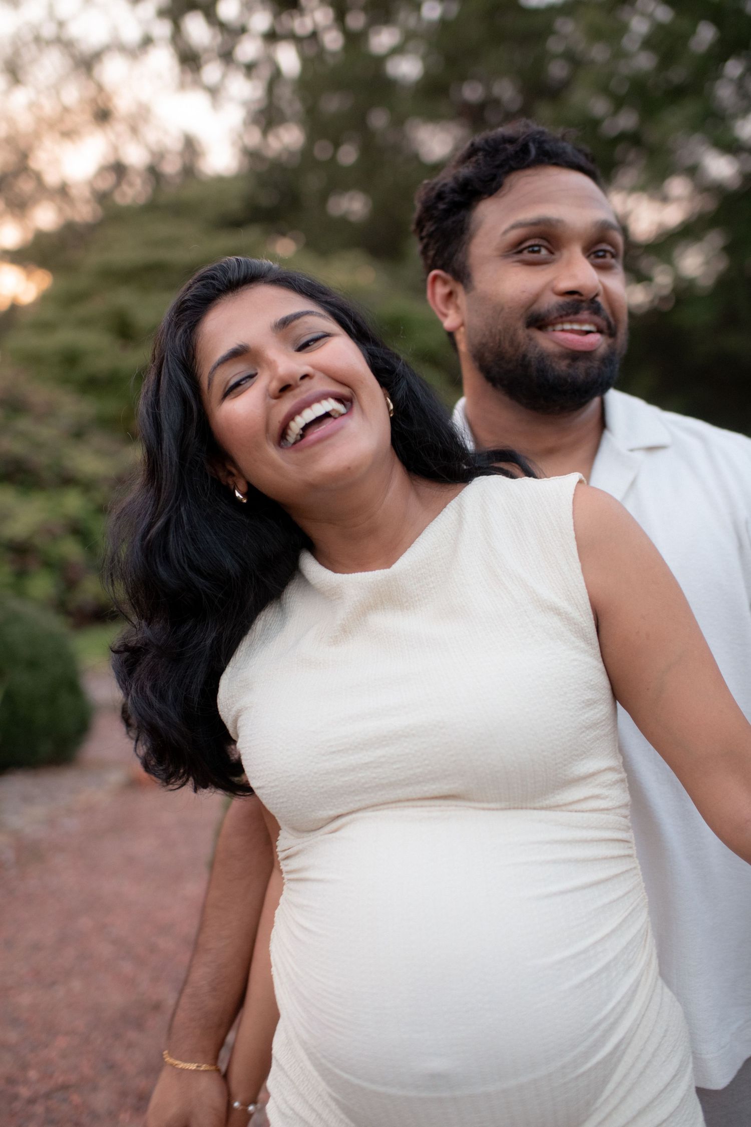 Joyful moments captured during outdoor maternity photoshoot.