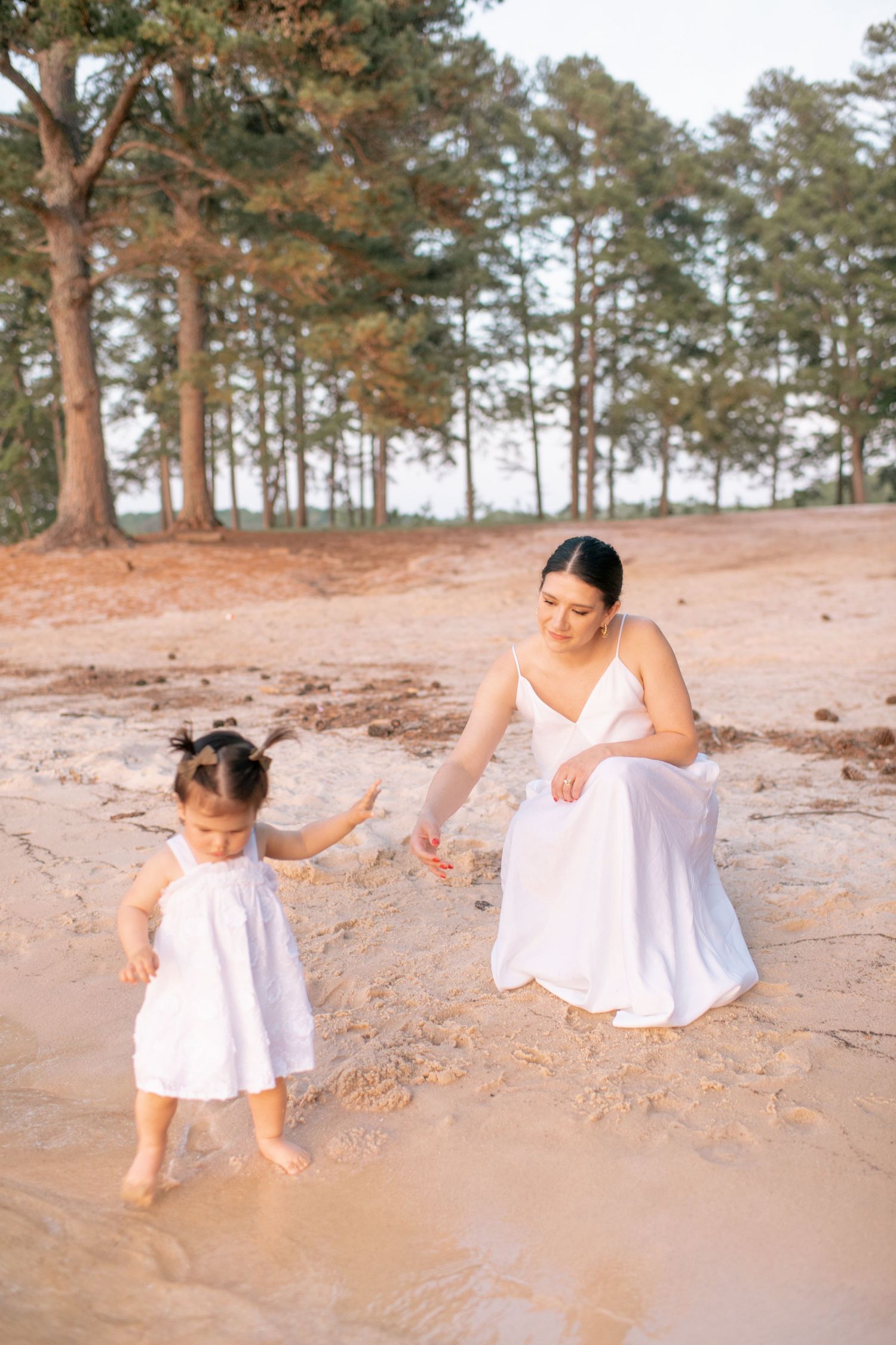 Family enjoys playtime in the sand at a lakeside beach.