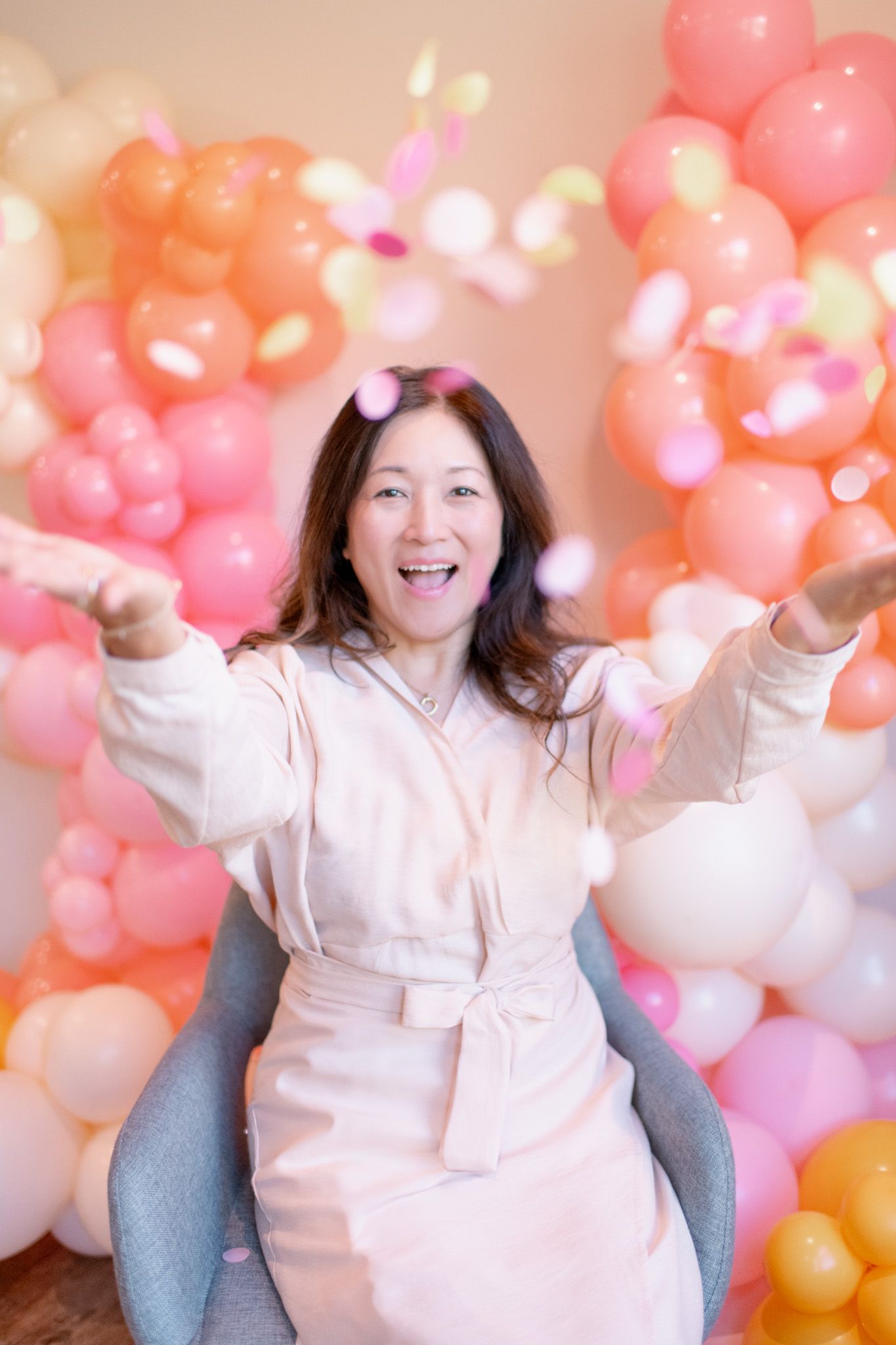 Vibrant pink and peach balloon garland creates a cheerful party backdrop.