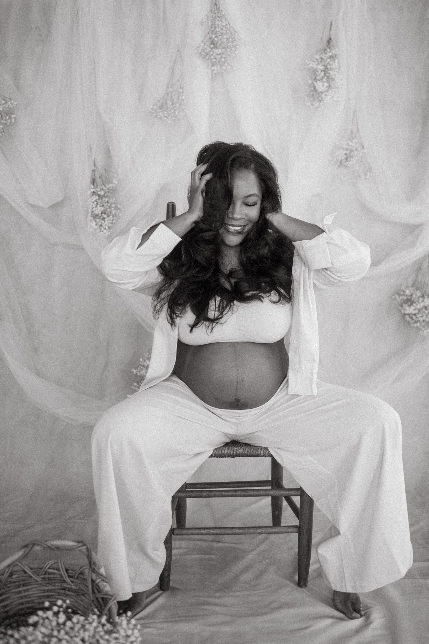Black and white maternity photography with dramatic poses and ethereal fabric backdrop.