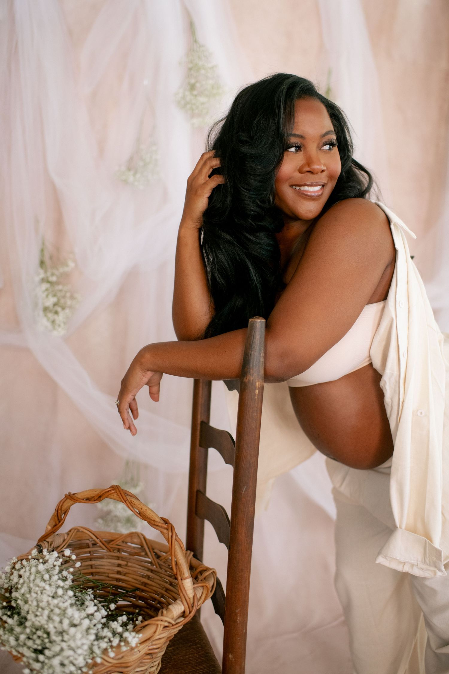 Creative maternity session incorporating baby's breath flowers and natural poses with wooden furniture.