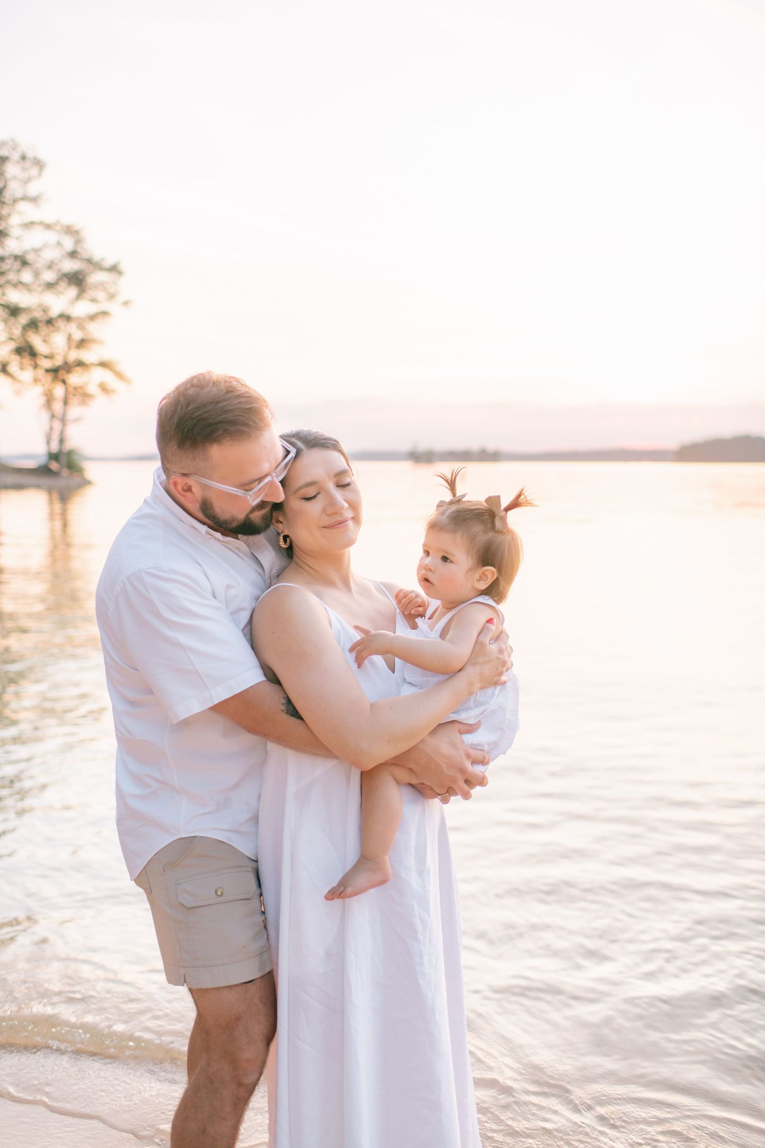 Tender family moment captured at sunset by the water.